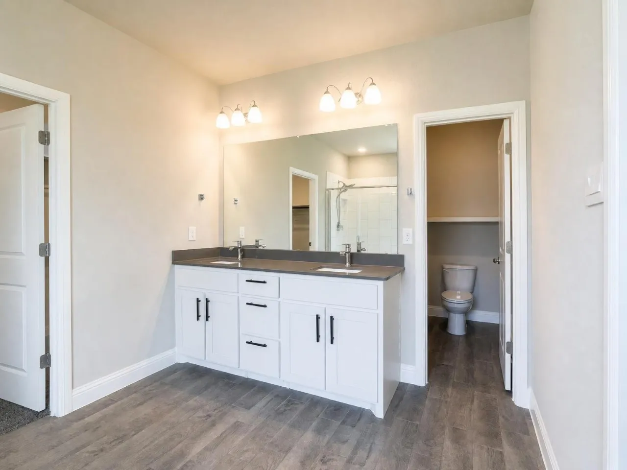 Dual vanity with a stone countertop, individual sinks, and matte black hardware