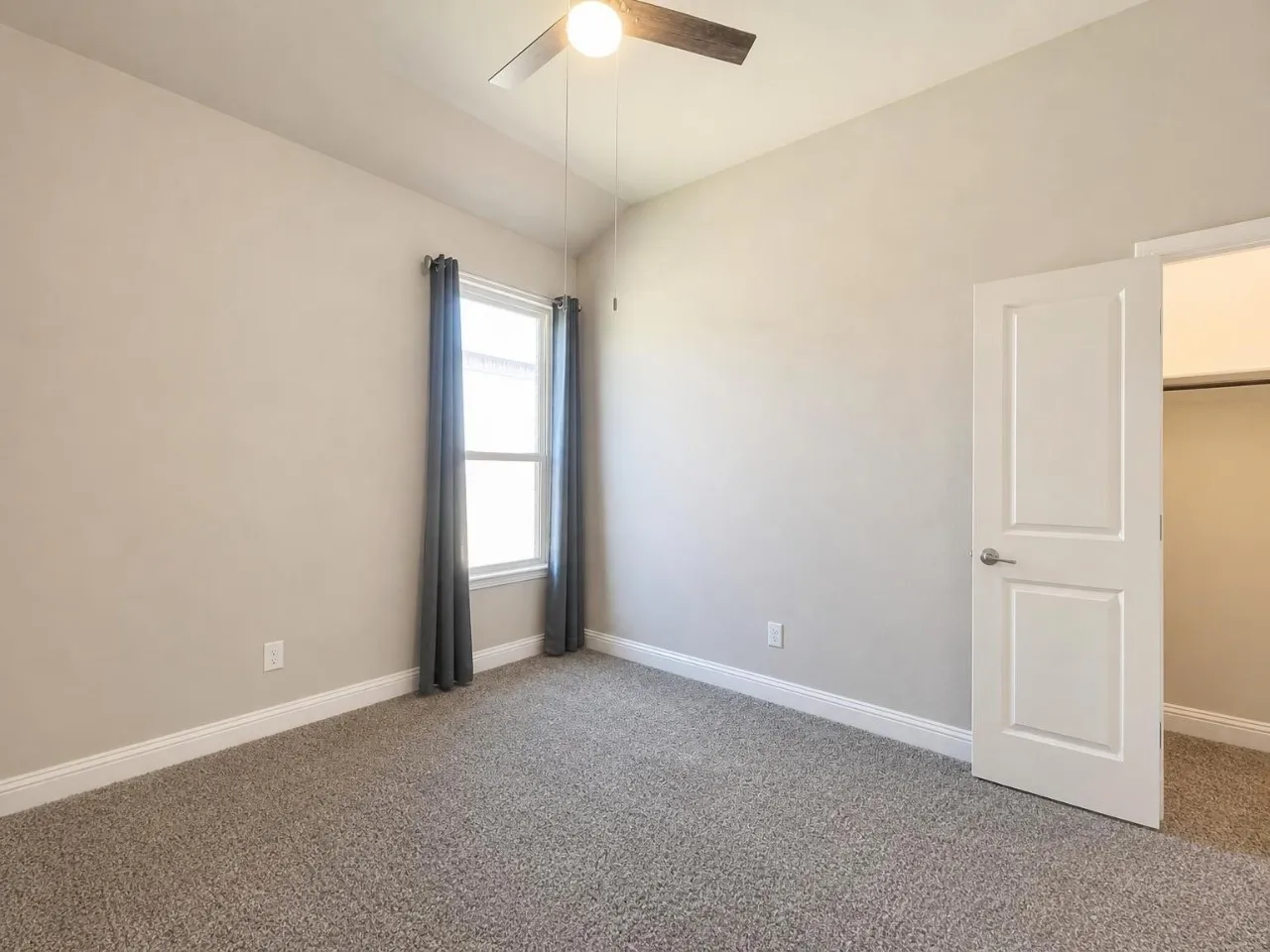 Vaulted ceiling with a ceiling fan, neutral wall paint, single window, and plush carpet flooring