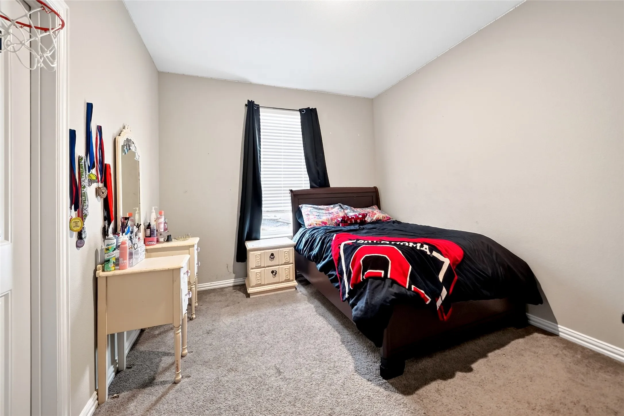 Carpeted room featuring a single window and neutral-toned walls