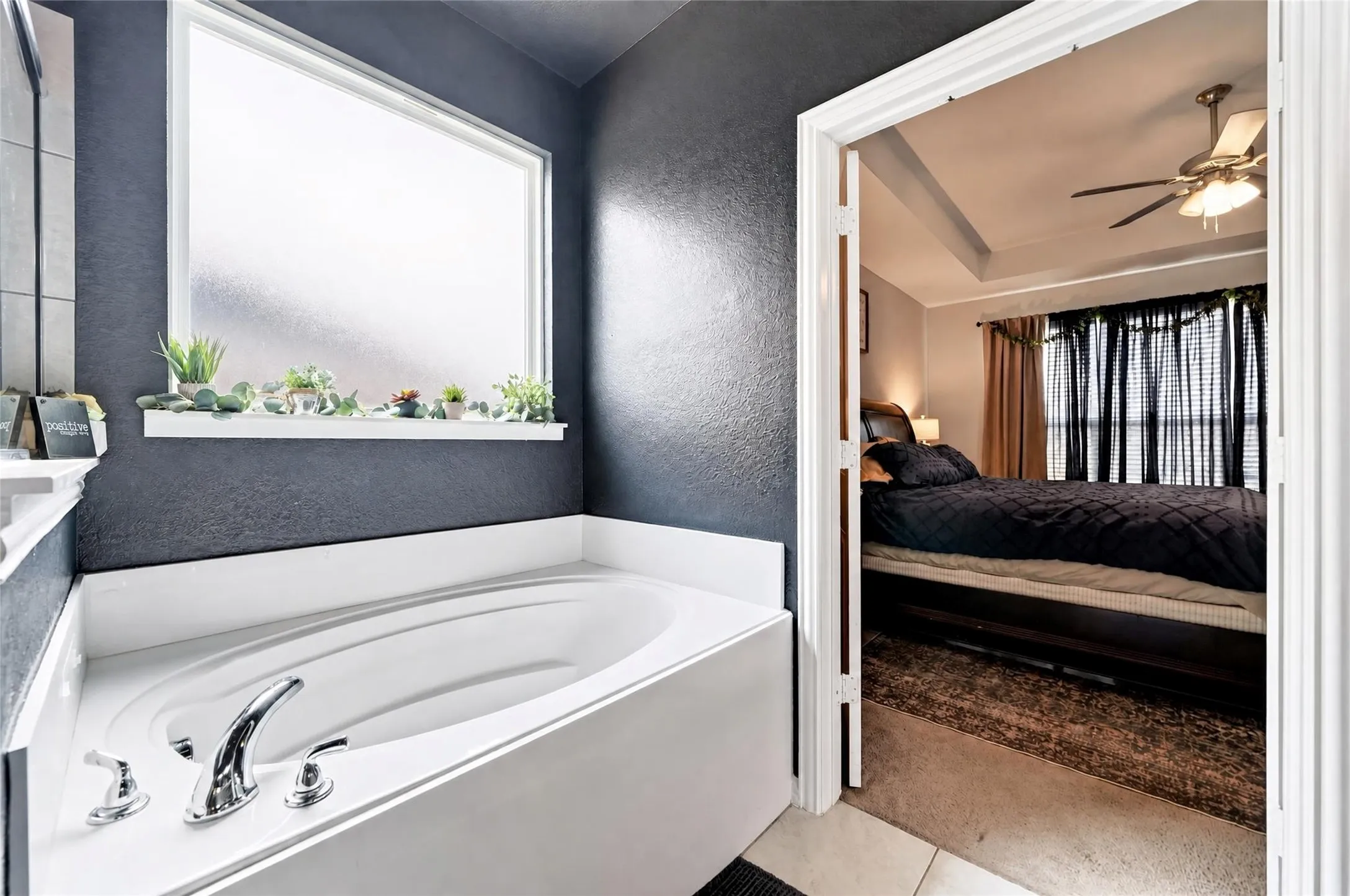 Built-in bathtub with chrome fixtures, frosted privacy window, and a white countertop