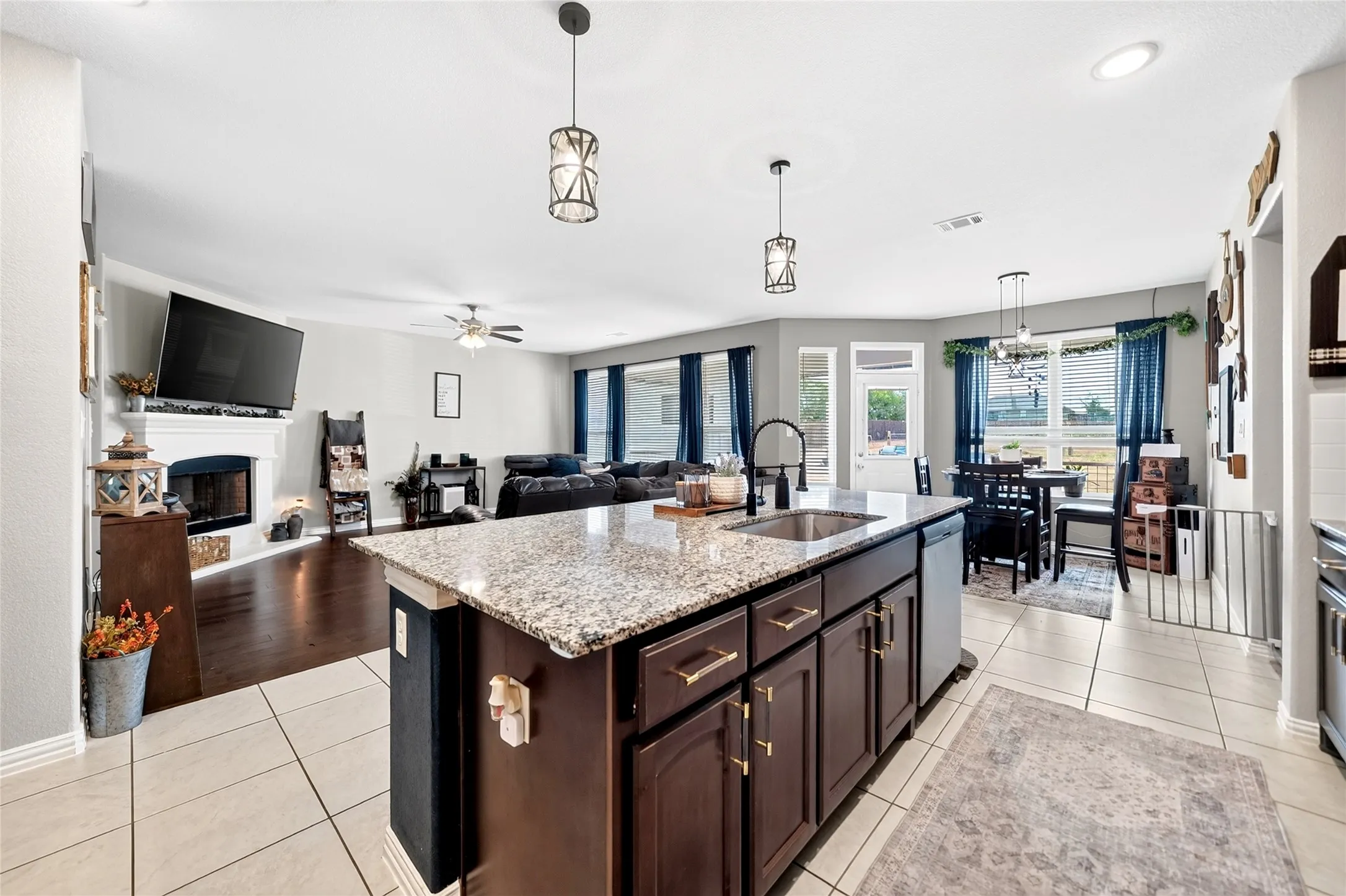 Open-concept living area with a kitchen island featuring a granite countertop and integrated sink