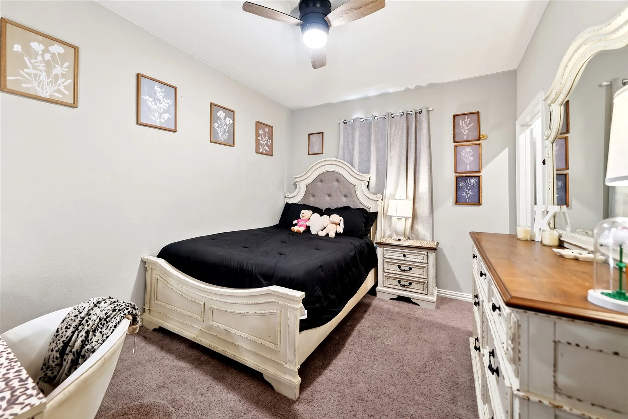 Carpeted flooring, ceiling fan with integrated lighting, window with light-filtering curtains, light-toned walls, and a built-in closet
