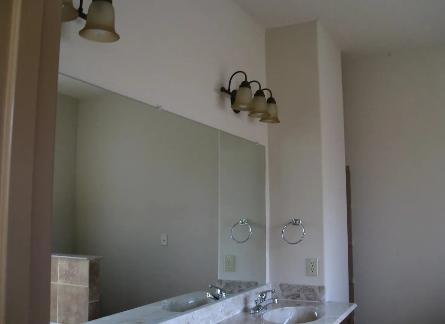 Dual vanity with integrated sinks, polished chrome faucets, and stone countertop