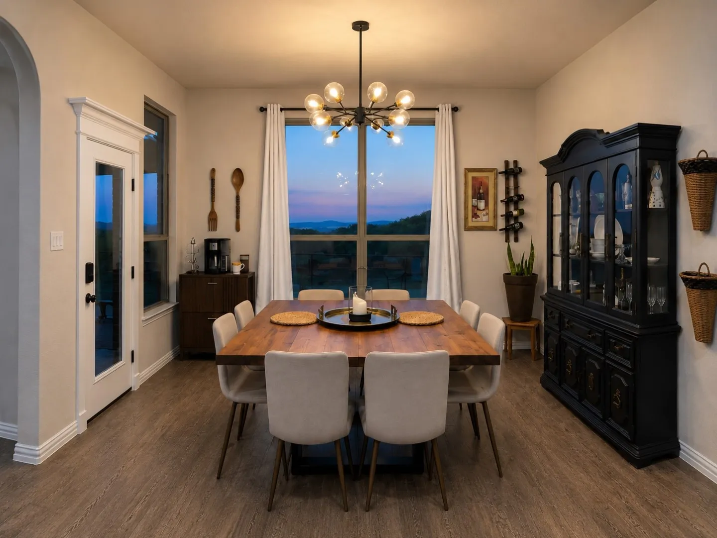 Dining area featuring a modern chandelier, wood-finish flooring, and expansive windows
