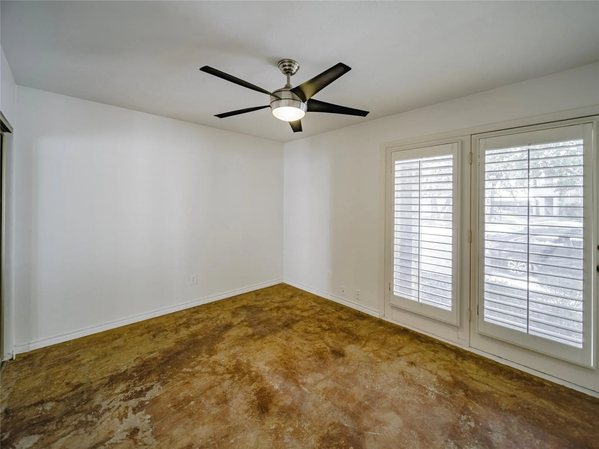 downstairs guest bathroom with stained concrete flooring and ceiling fan