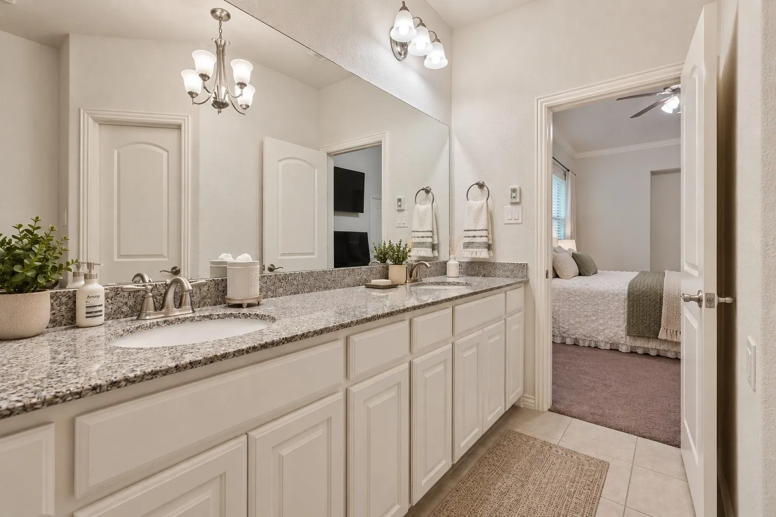 Dual vanity with stone-finish countertops, undermount sinks, and white shaker-style cabinetry