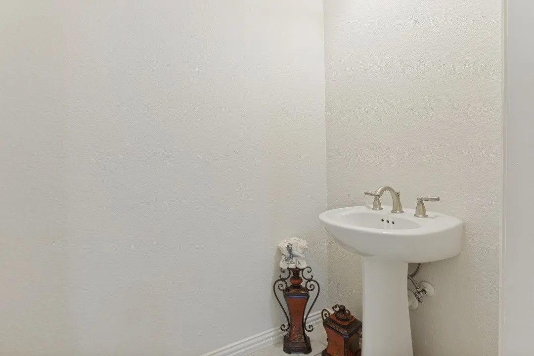 Pedestal sink with a brushed nickel faucet set