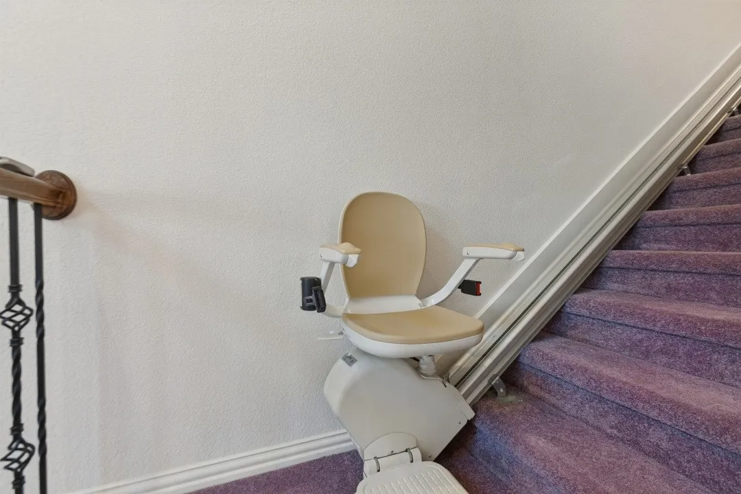 Stair lift installed at the base of stairs for enhanced accessibility.
