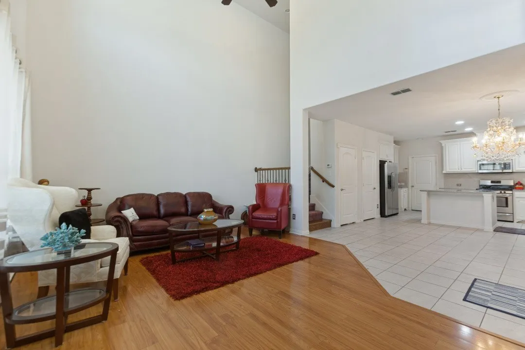 The living room features high ceilings and large windows that provide abundant natural light and an airy, spacious atmosphere.