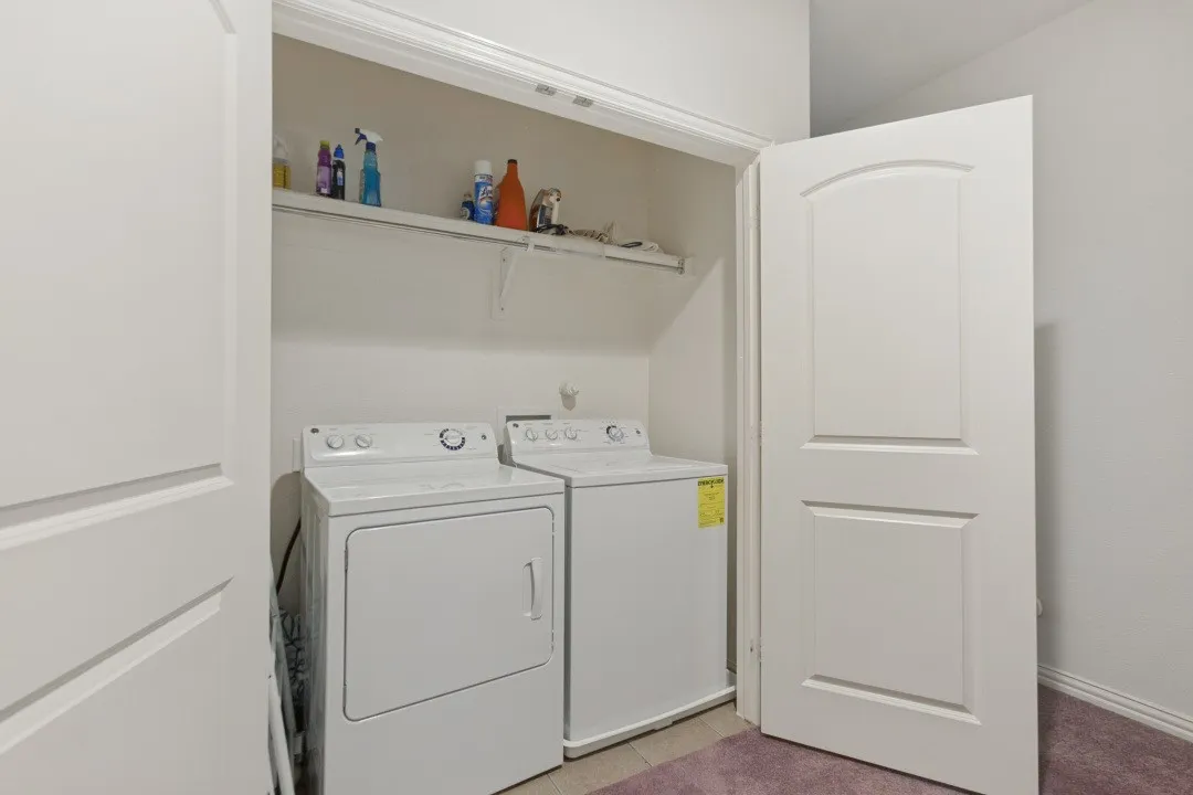 Dedicated laundry closet with built-in shelving, providing functional utility