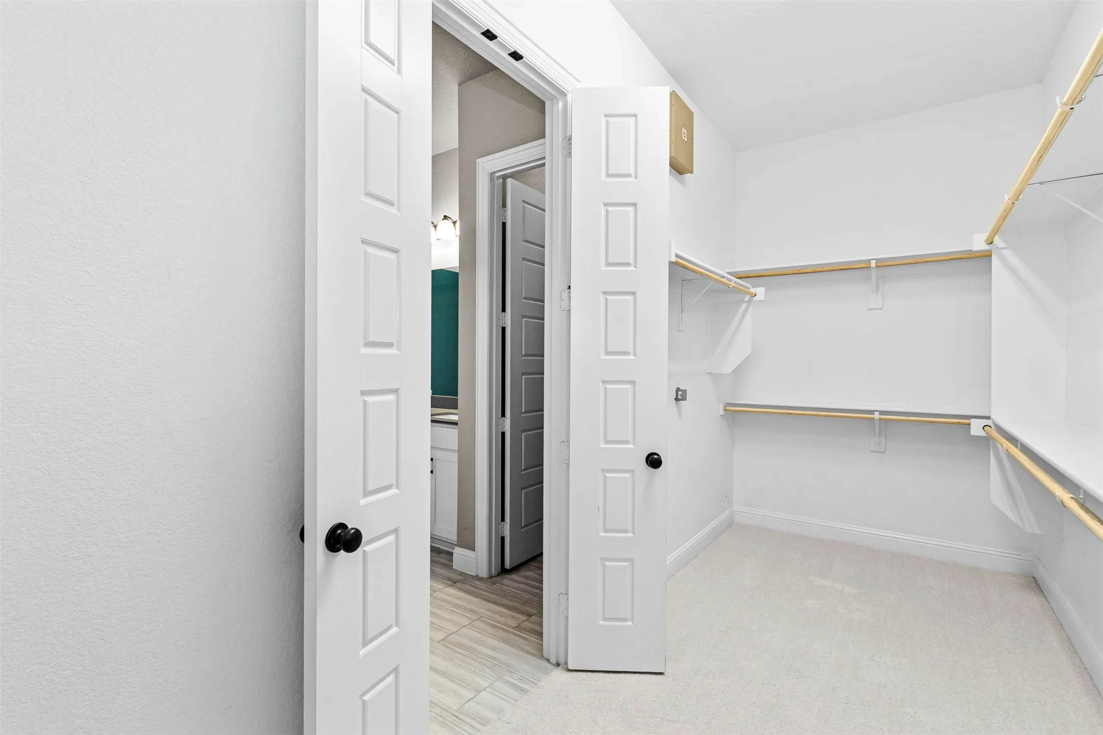 Spacious walk-in closet with extensive built-in shelving and hanging rods