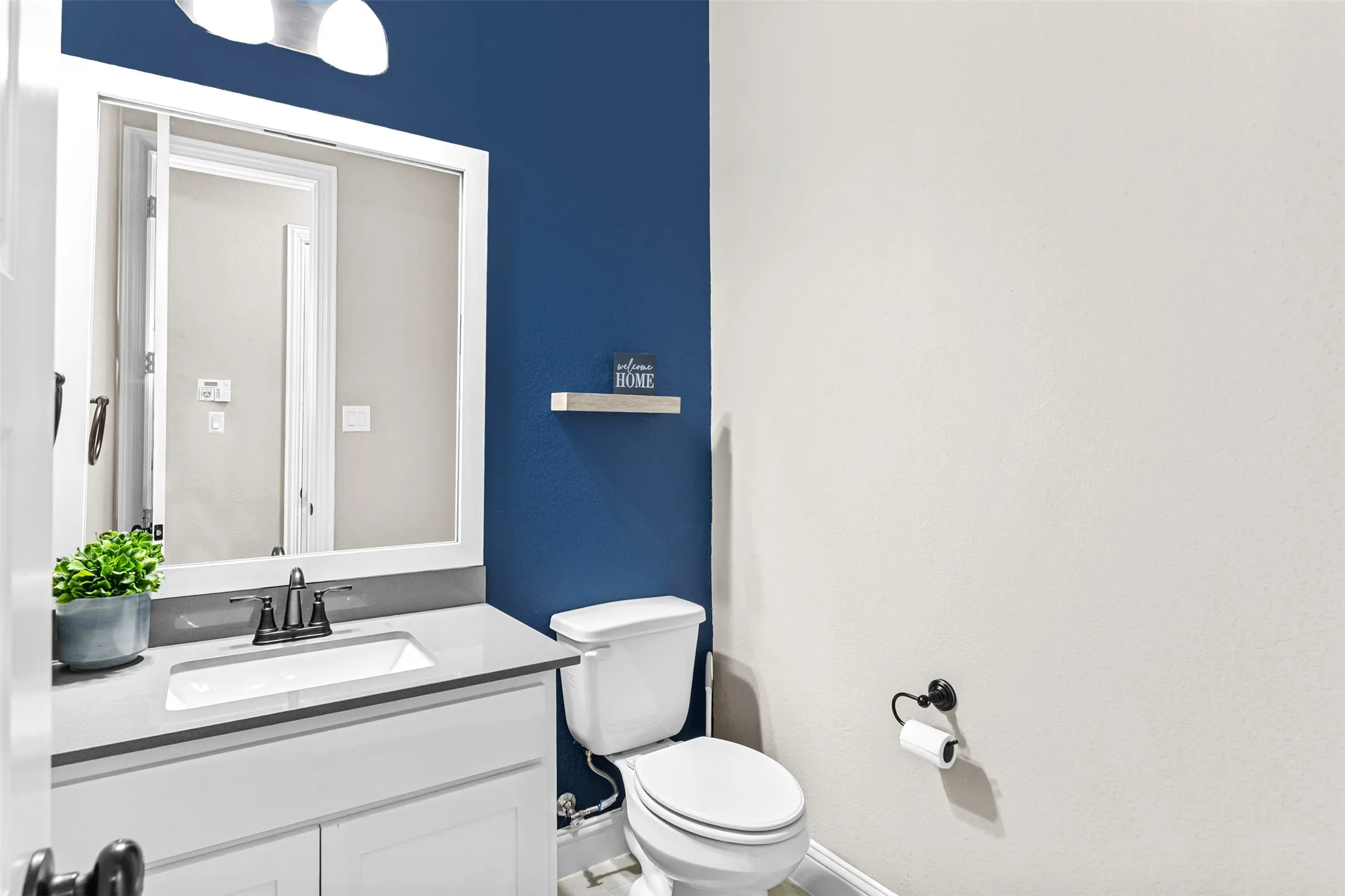 Vanity with white shaker-style cabinetry, undermount sink, and light gray countertop