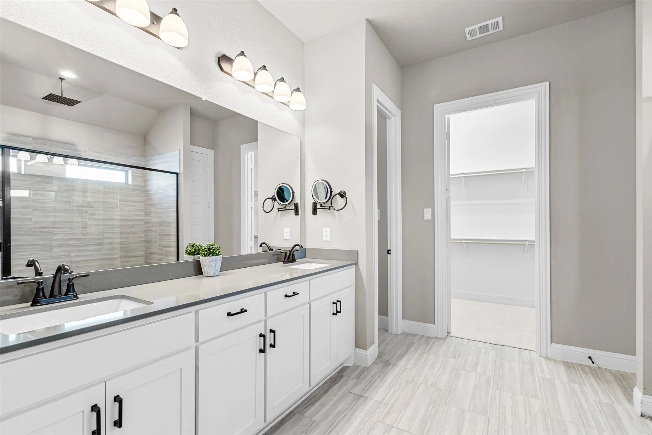 Dual vanity with integrated sinks, quartz-finish countertop, and white shaker-style cabinetry