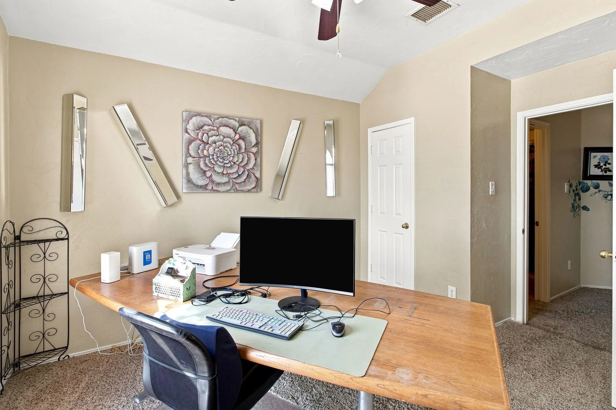Vaulted ceiling with an attached fan, textured walls, and carpet flooring
