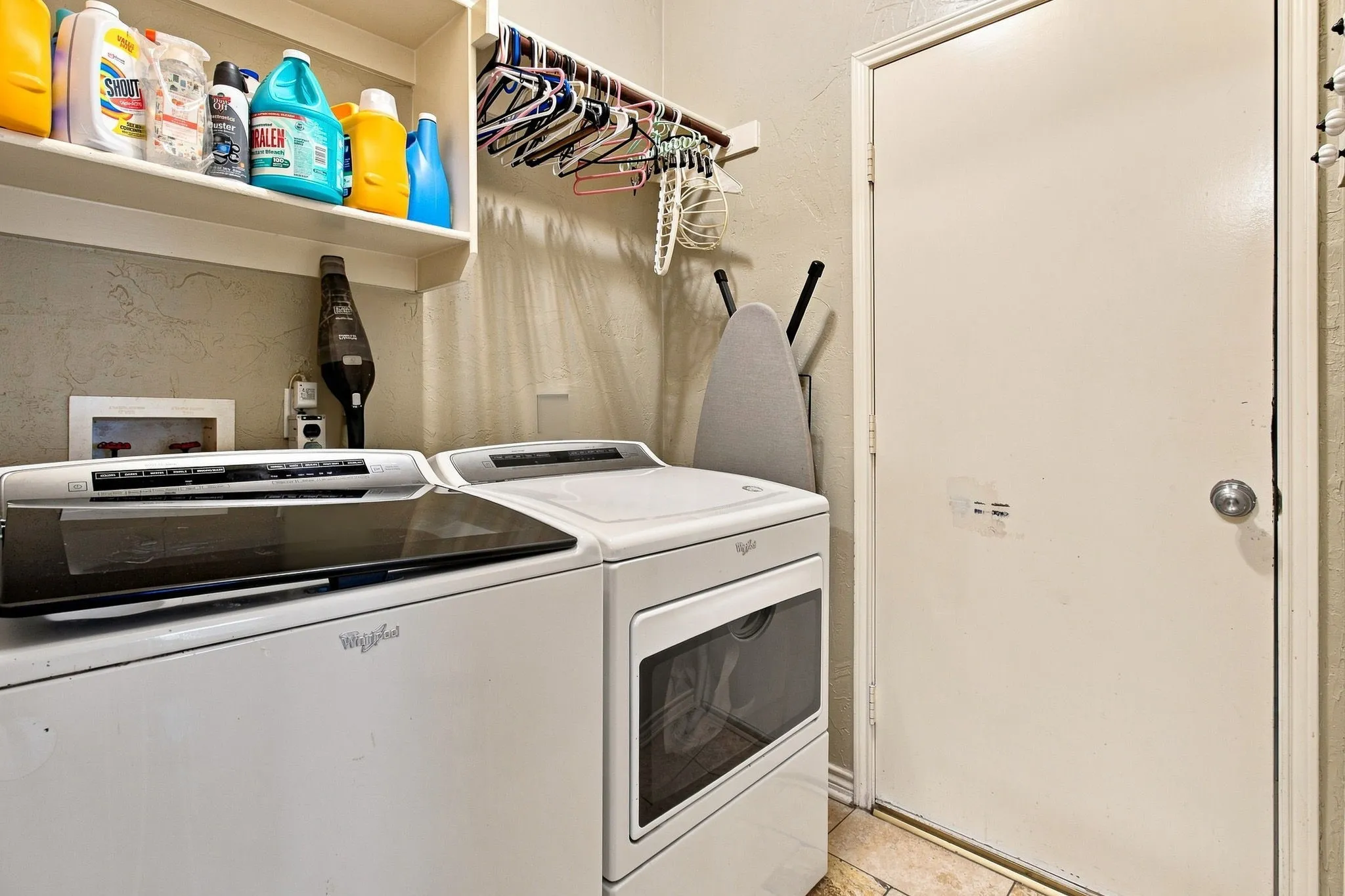Laundry area featuring built-in shelving and tile flooring