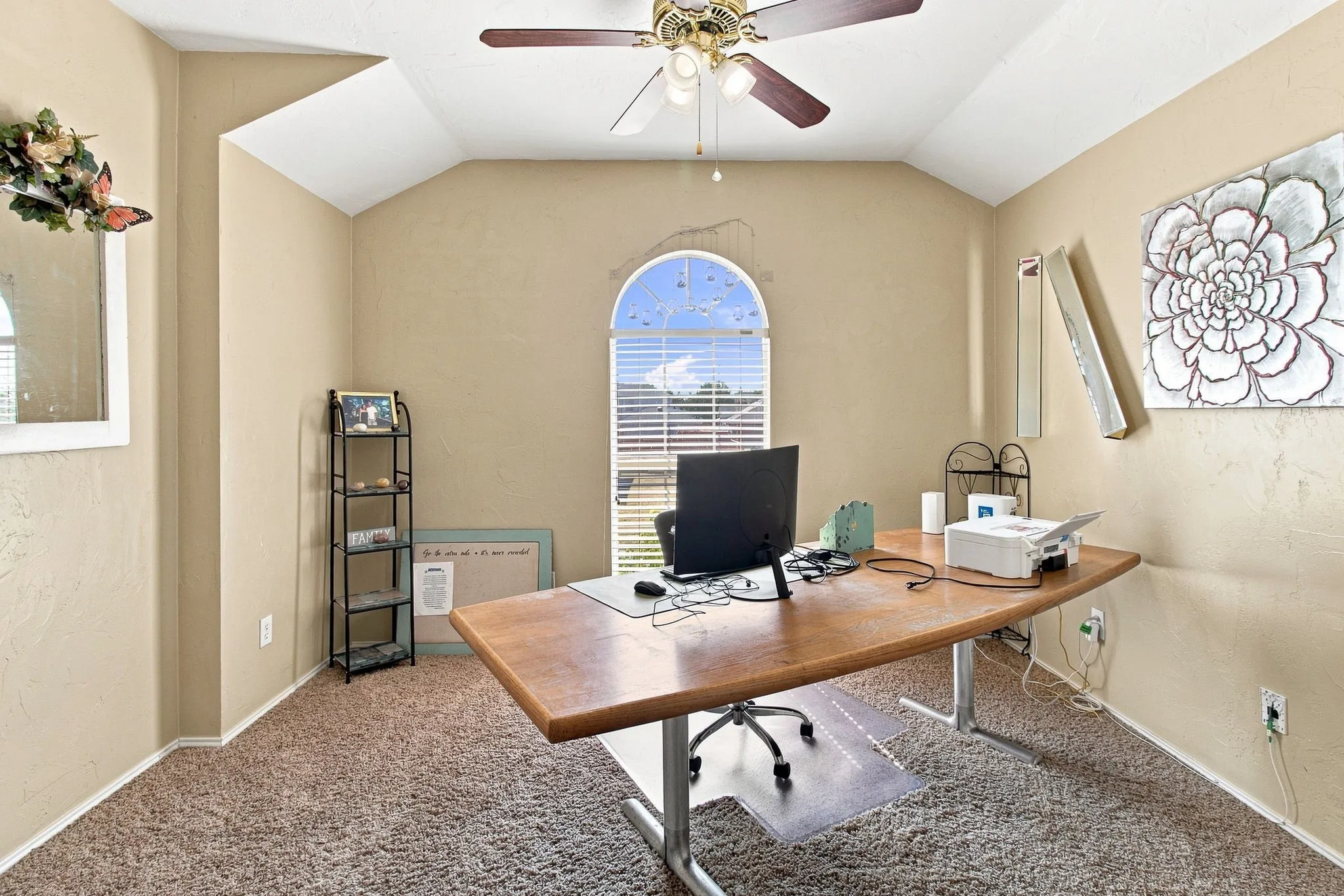Vaulted ceiling with a ceiling fan, arched window with horizontal blinds, and carpeted flooring