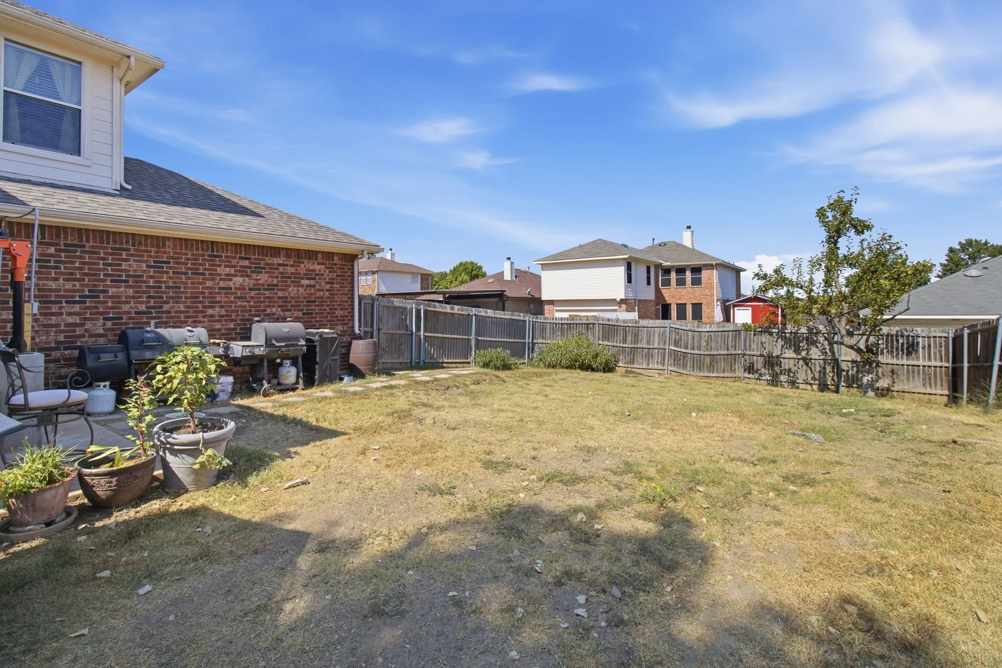 Expansive backyard space featuring a wood fence perimeter