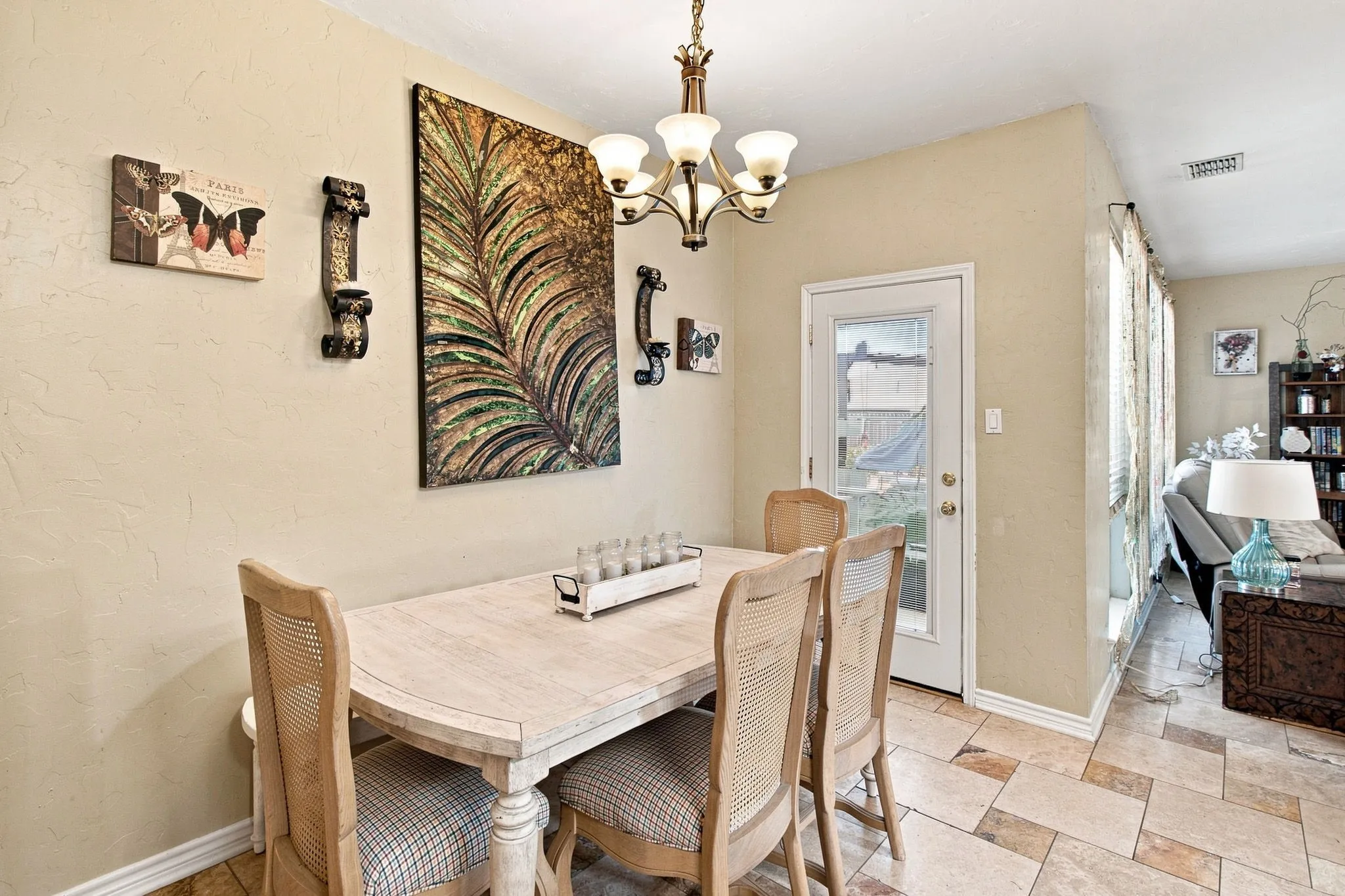 Dining area featuring a brass chandelier, tiled flooring, and a glass-paned exterior door