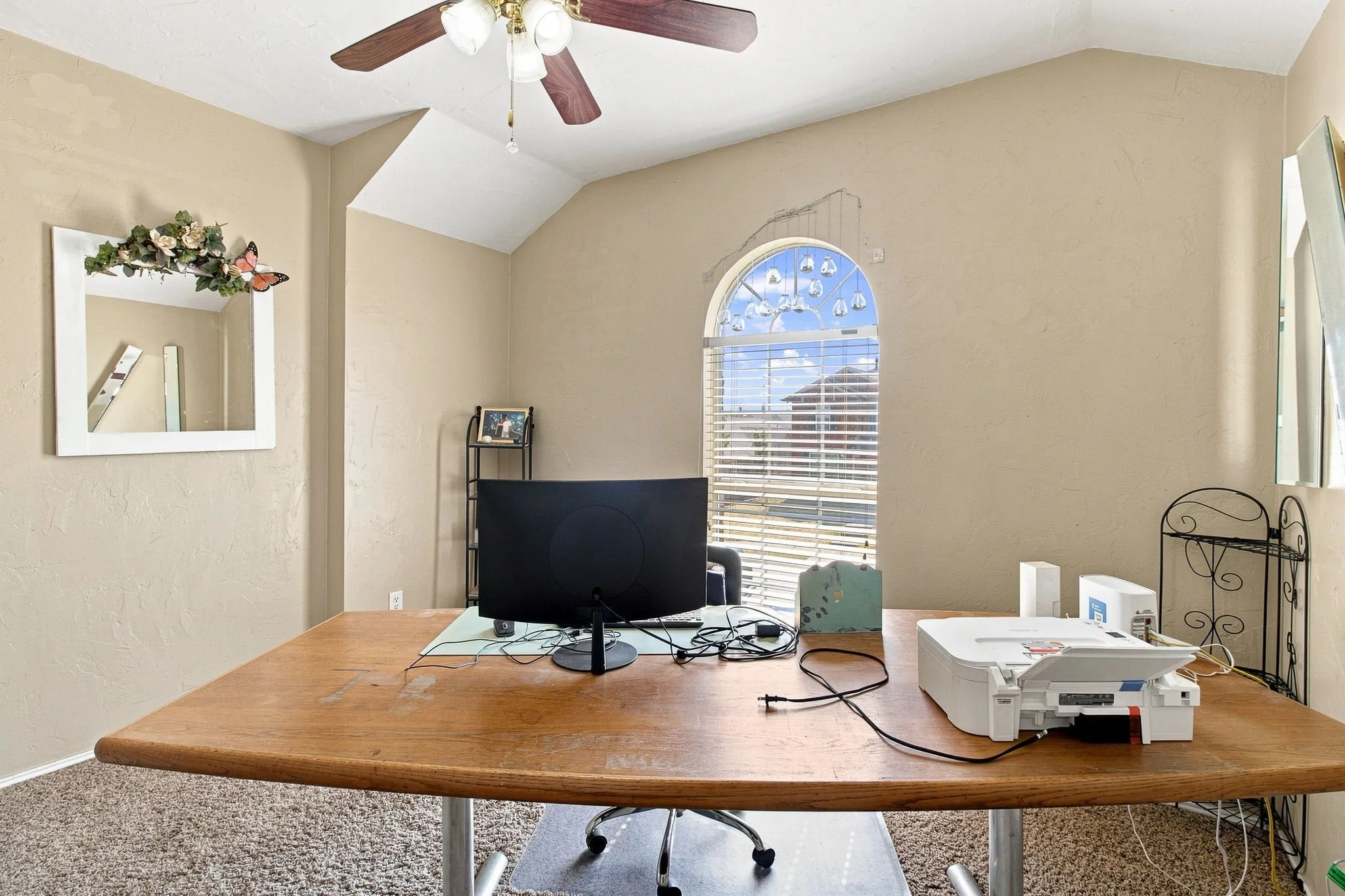 Vaulted ceiling with an attached ceiling fan, arched window with horizontal blinds, and textured wall finish