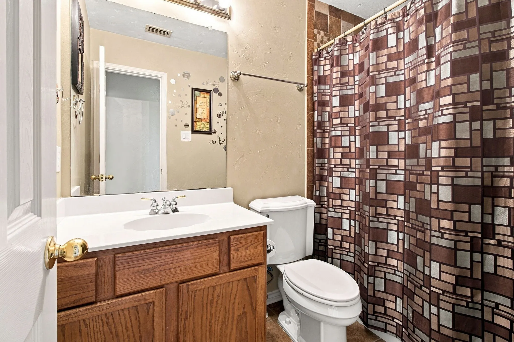 Wood-finish vanity with a white countertop and drop-in sink