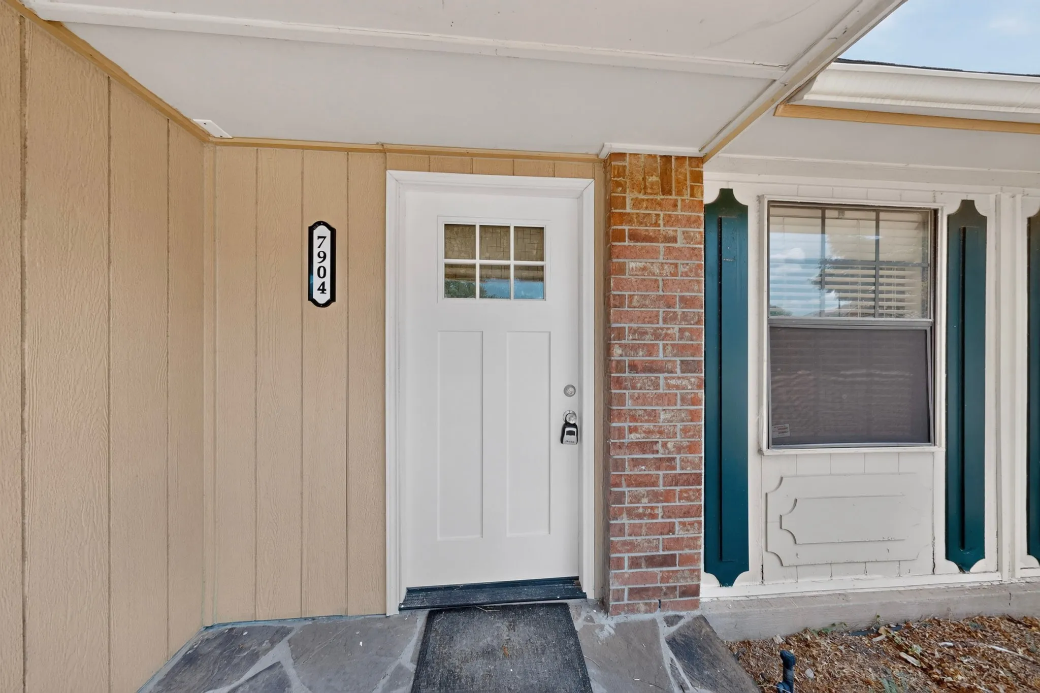 Stone step entry with a white paneled front door featuring divided lites