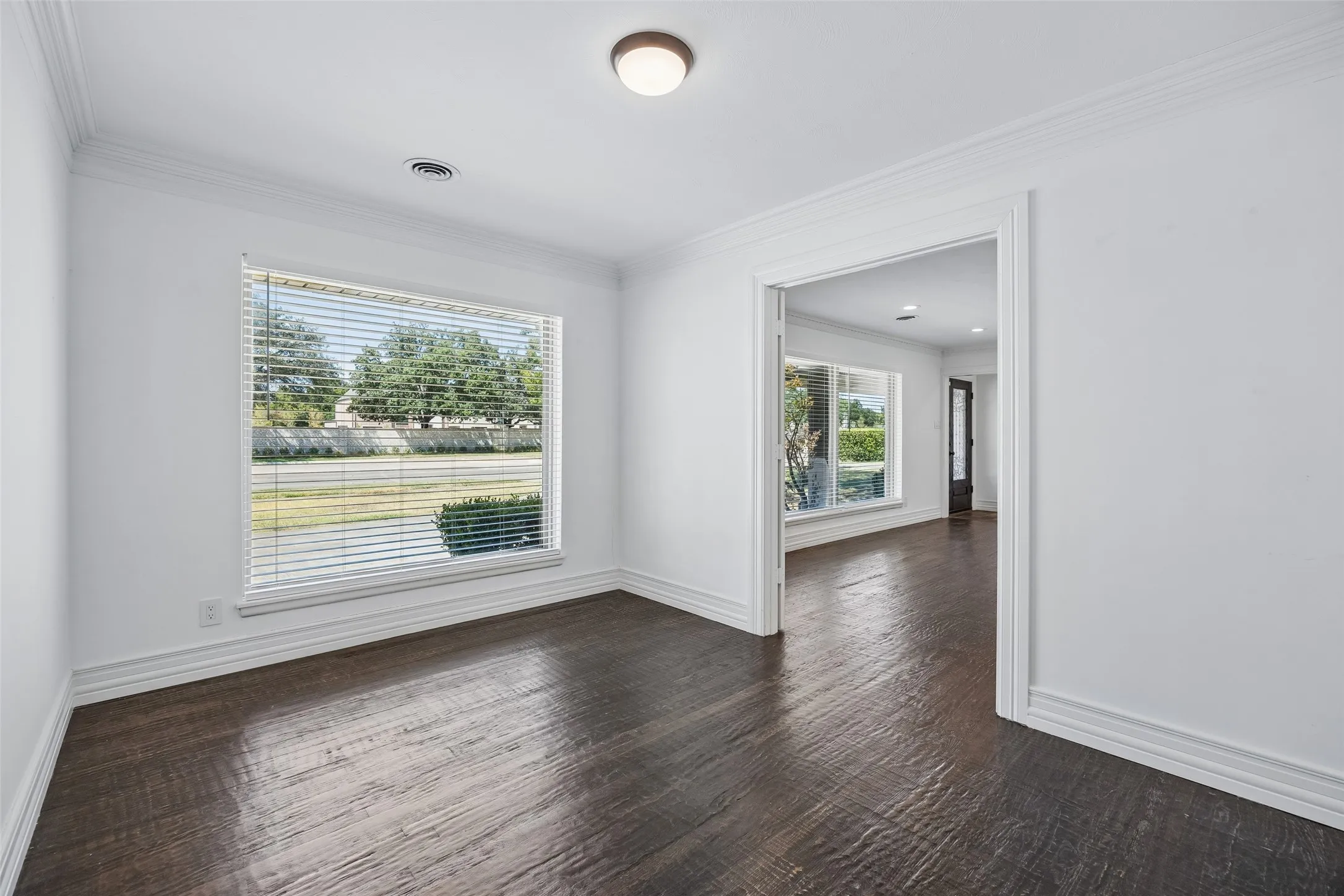 Wood-finish flooring, crisp white walls, and a recessed ceiling light fixture