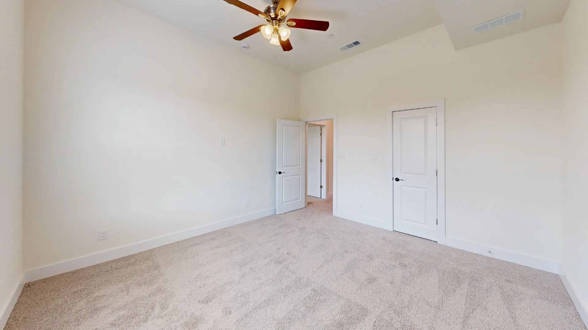 Vaulted ceiling, ceiling fan, neutral wall paint, white trim, and carpeted flooring