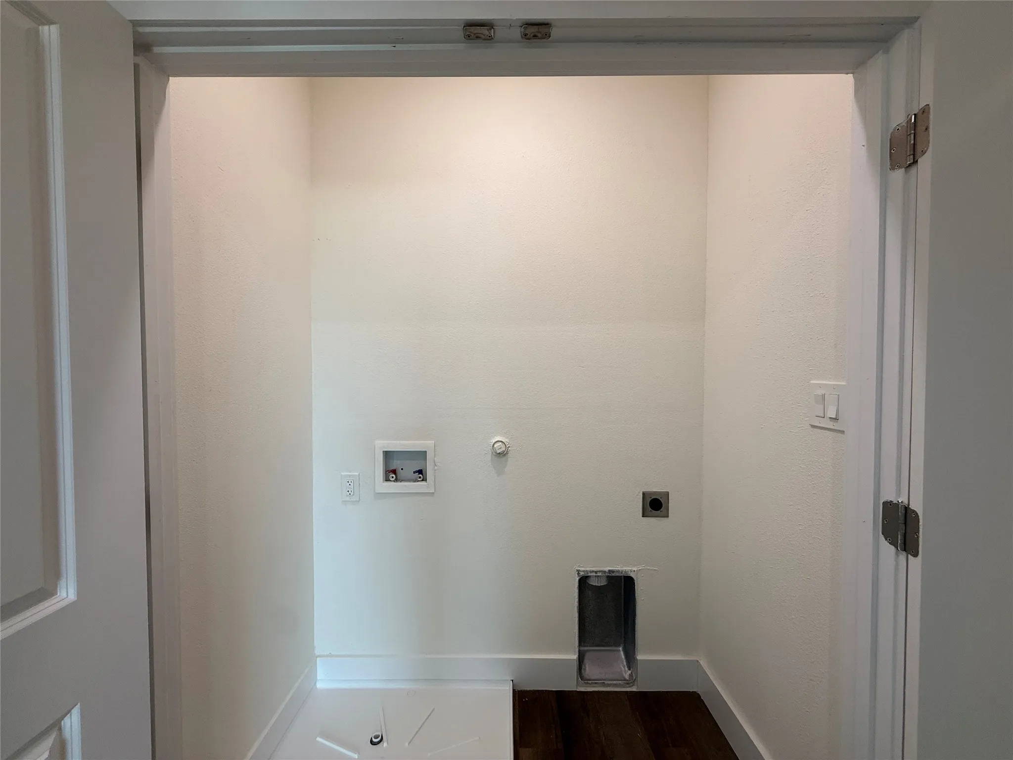 Bathroom featuring a shower/tub combination, wall-mounted showerhead, and wood-finish flooring