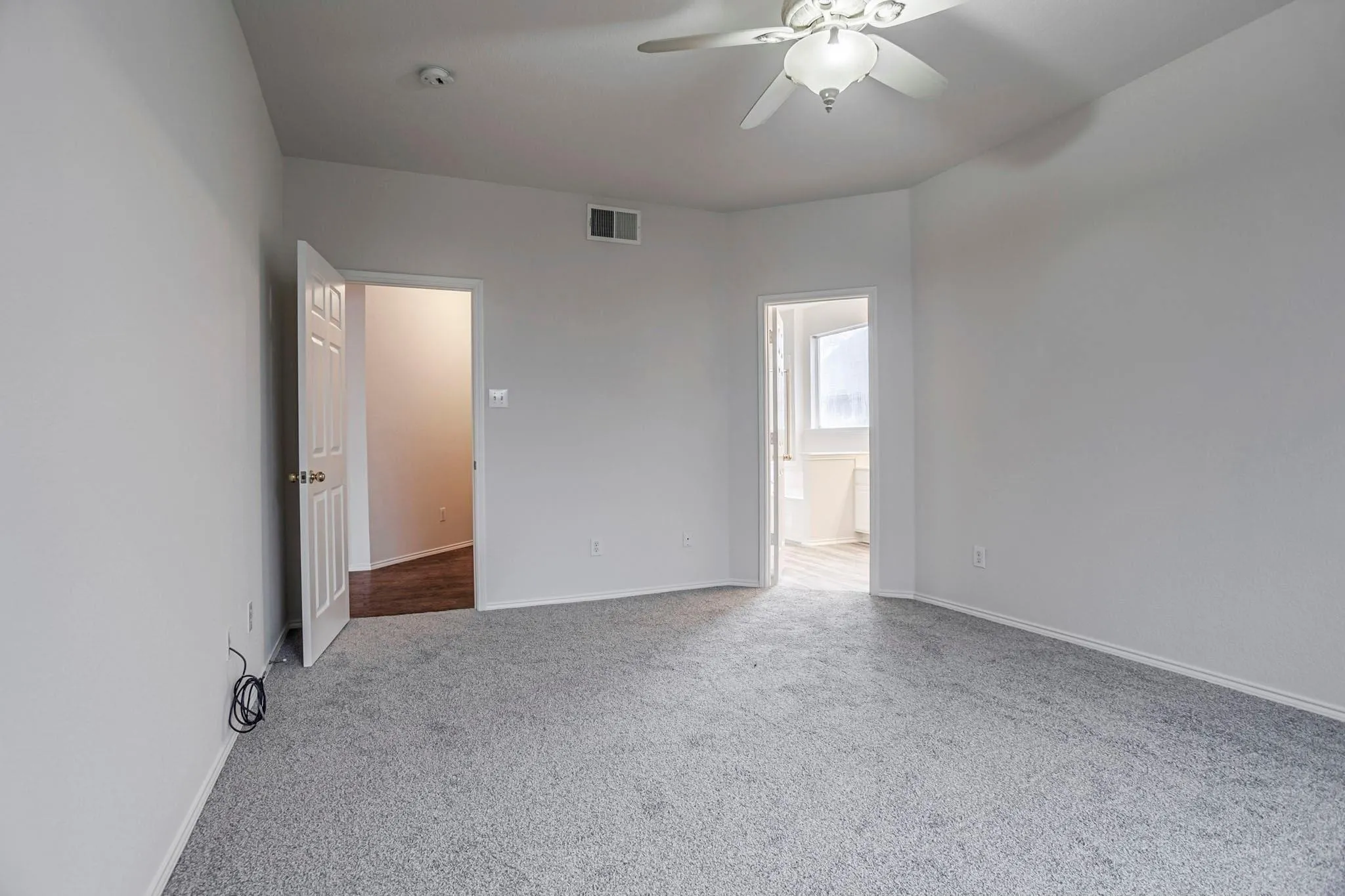Recessed ceiling with an integrated ceiling fan and light fixture, plush carpeting, and light-toned wall finishes