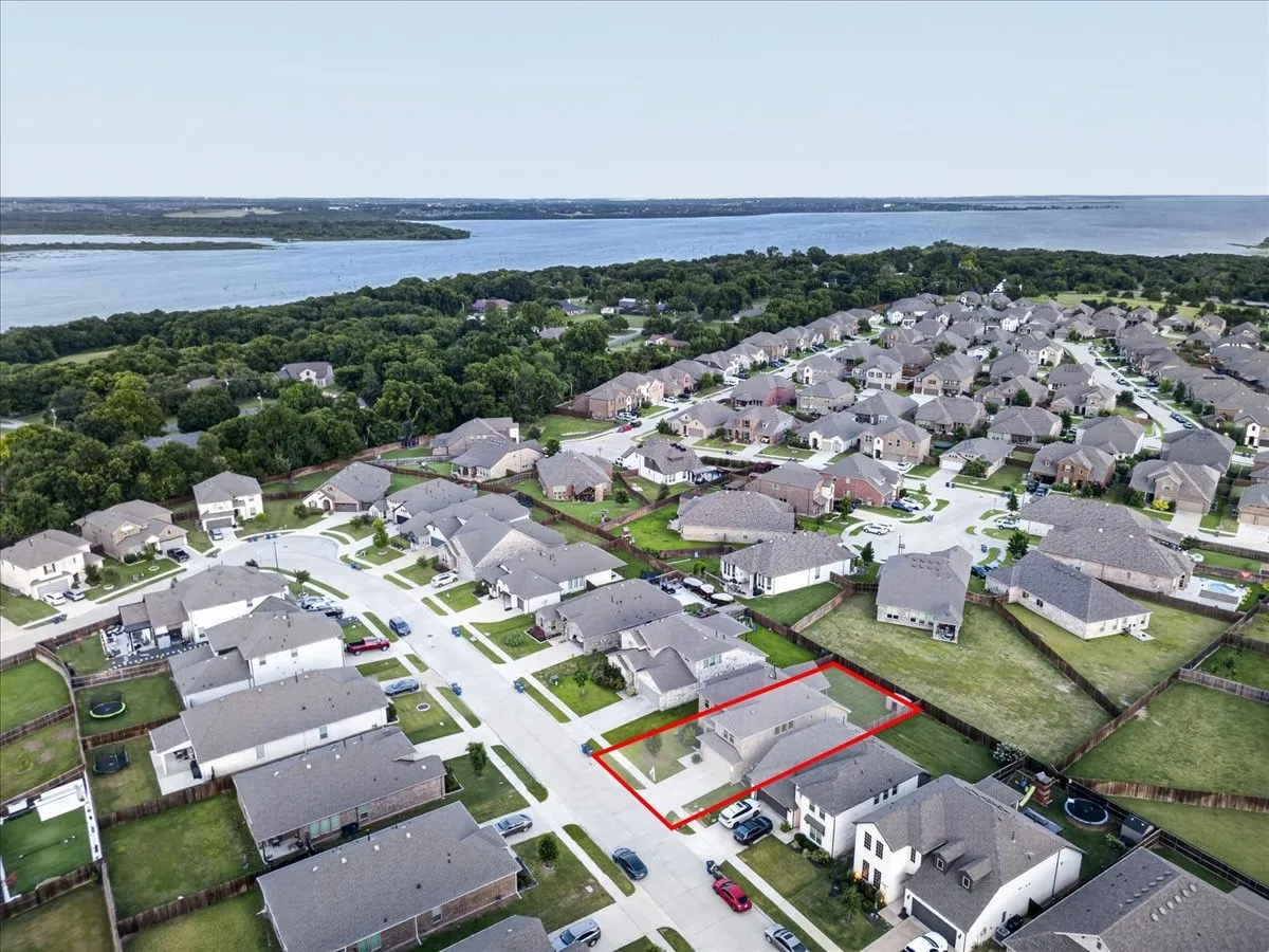 Residential neighborhood with a body of water and treeline in the background