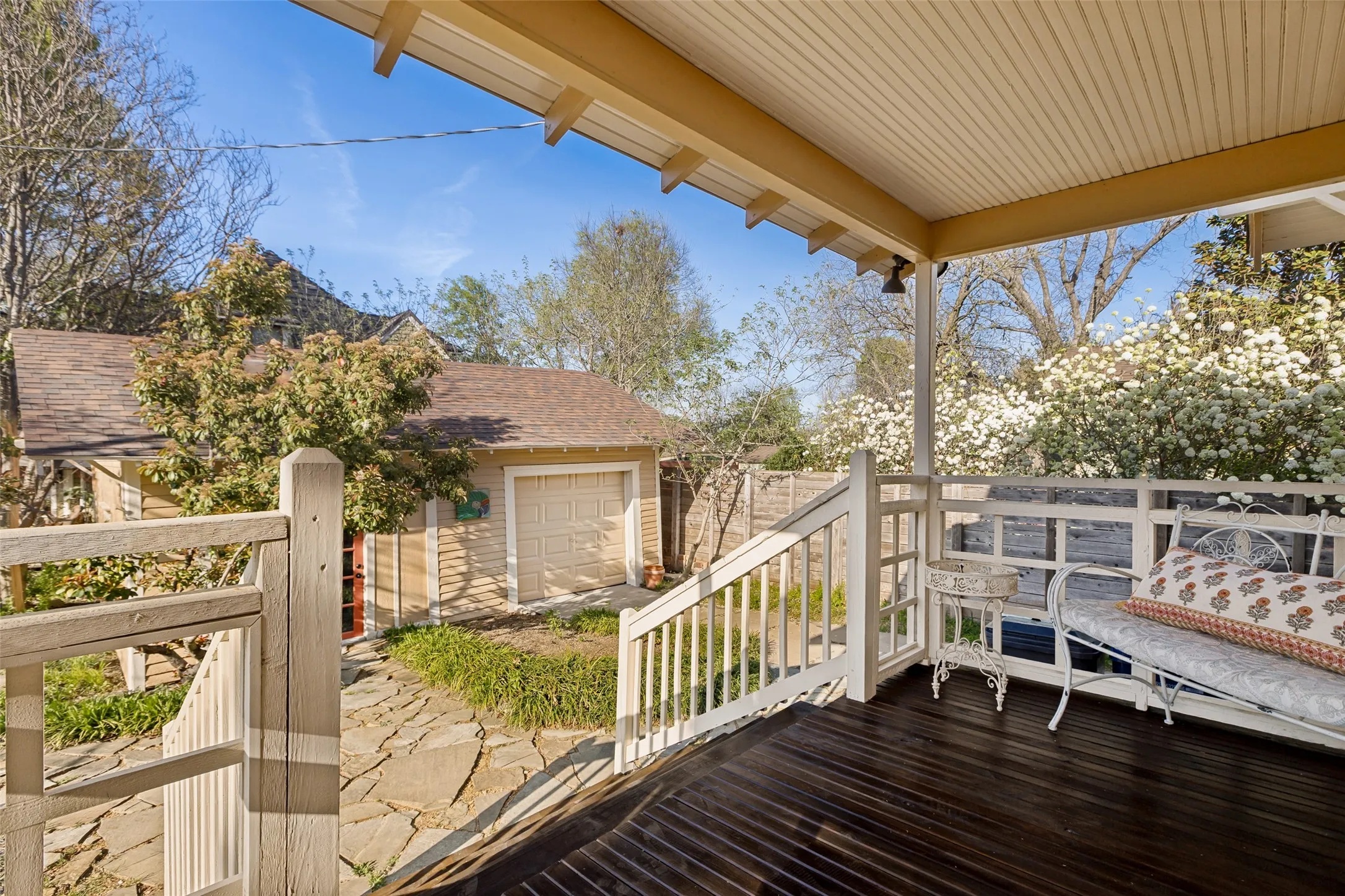 Covered porch featuring dark wood-finish flooring and white painted railings