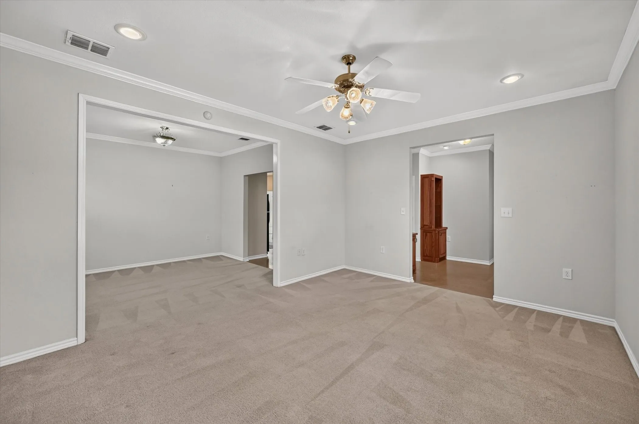 Carpeted living area with crown molding, recessed lighting, and a ceiling fan