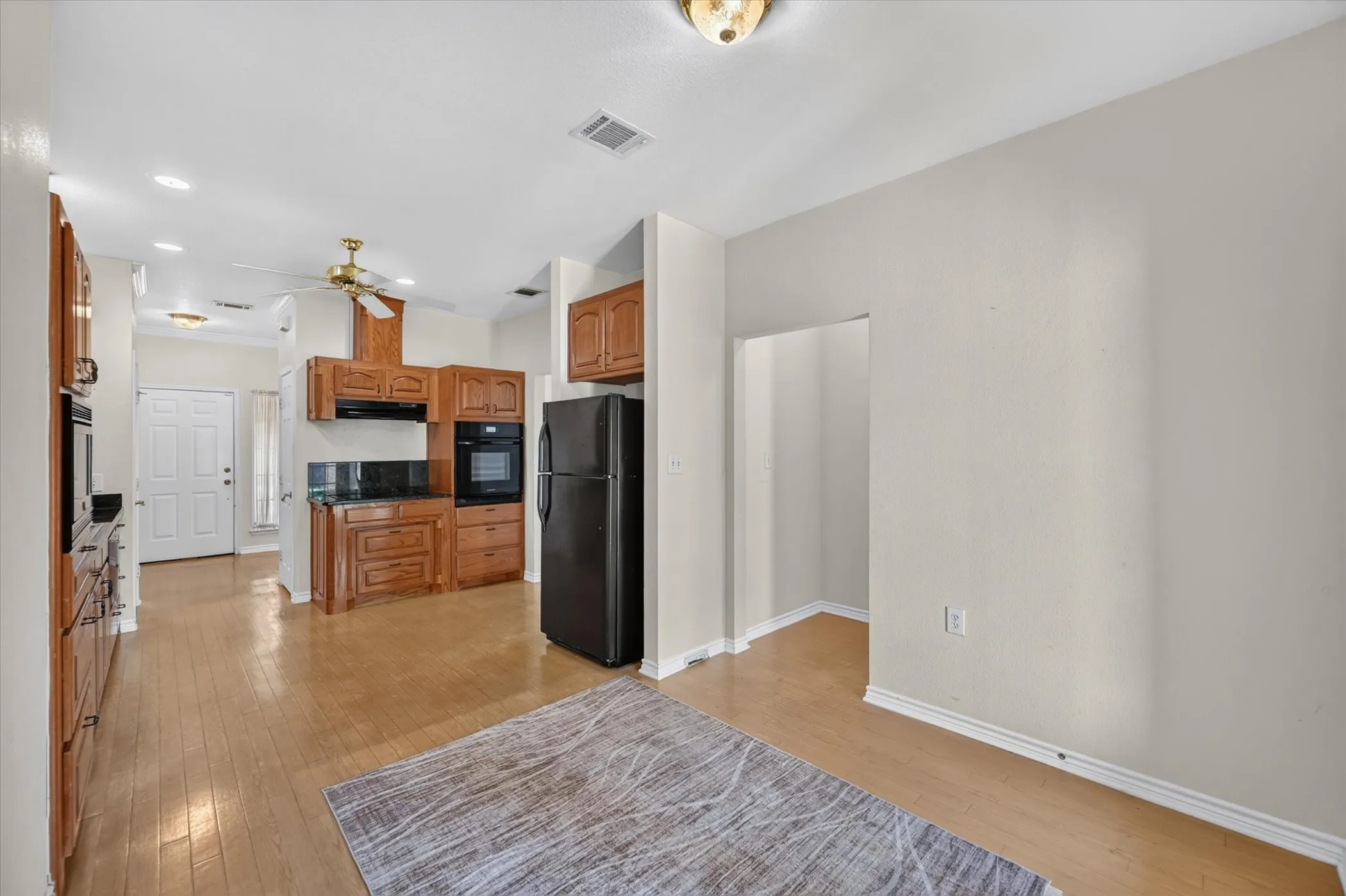 Kitchen featuring wood-finish flooring, recessed lighting, wood cabinetry, and a ceiling fan