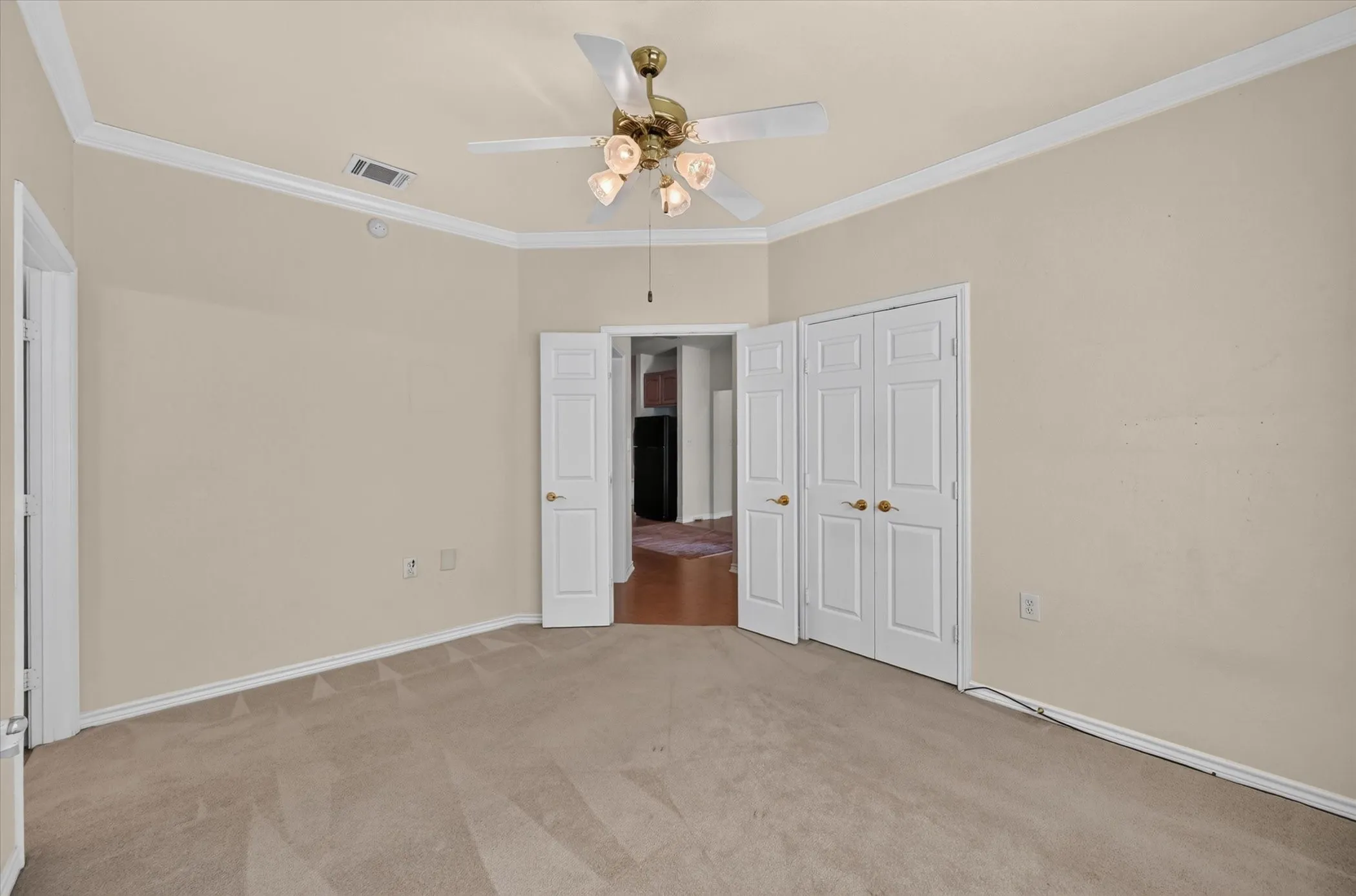 Recessed ceiling with crown molding, carpet flooring, a ceiling fan with integrated lighting, and painted walls