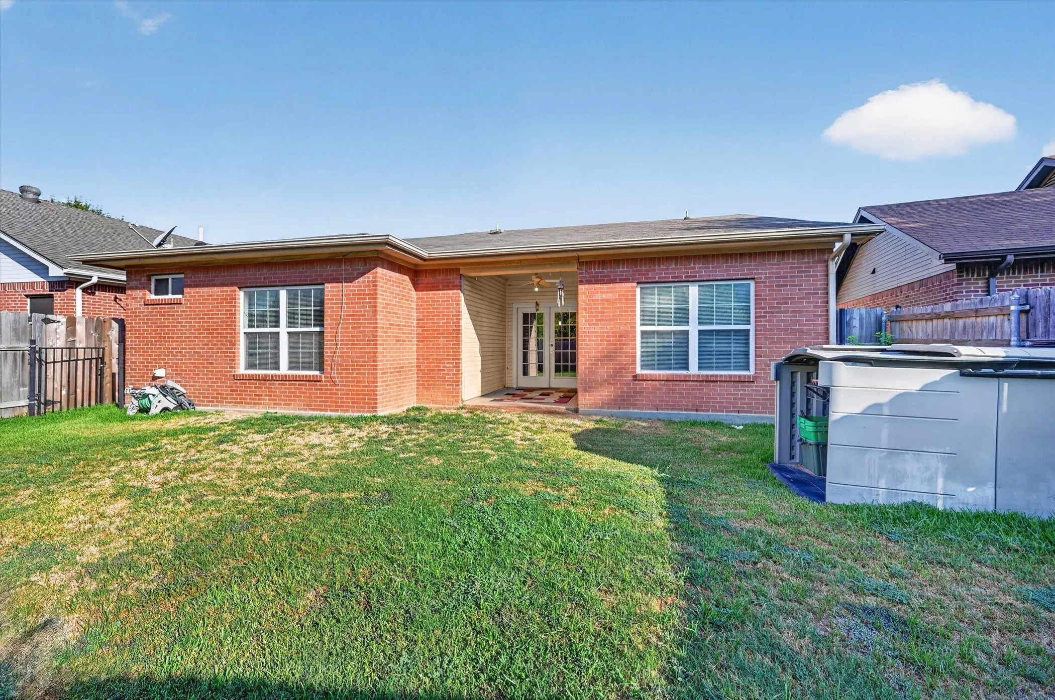 Brick exterior with multiple windows and a covered patio