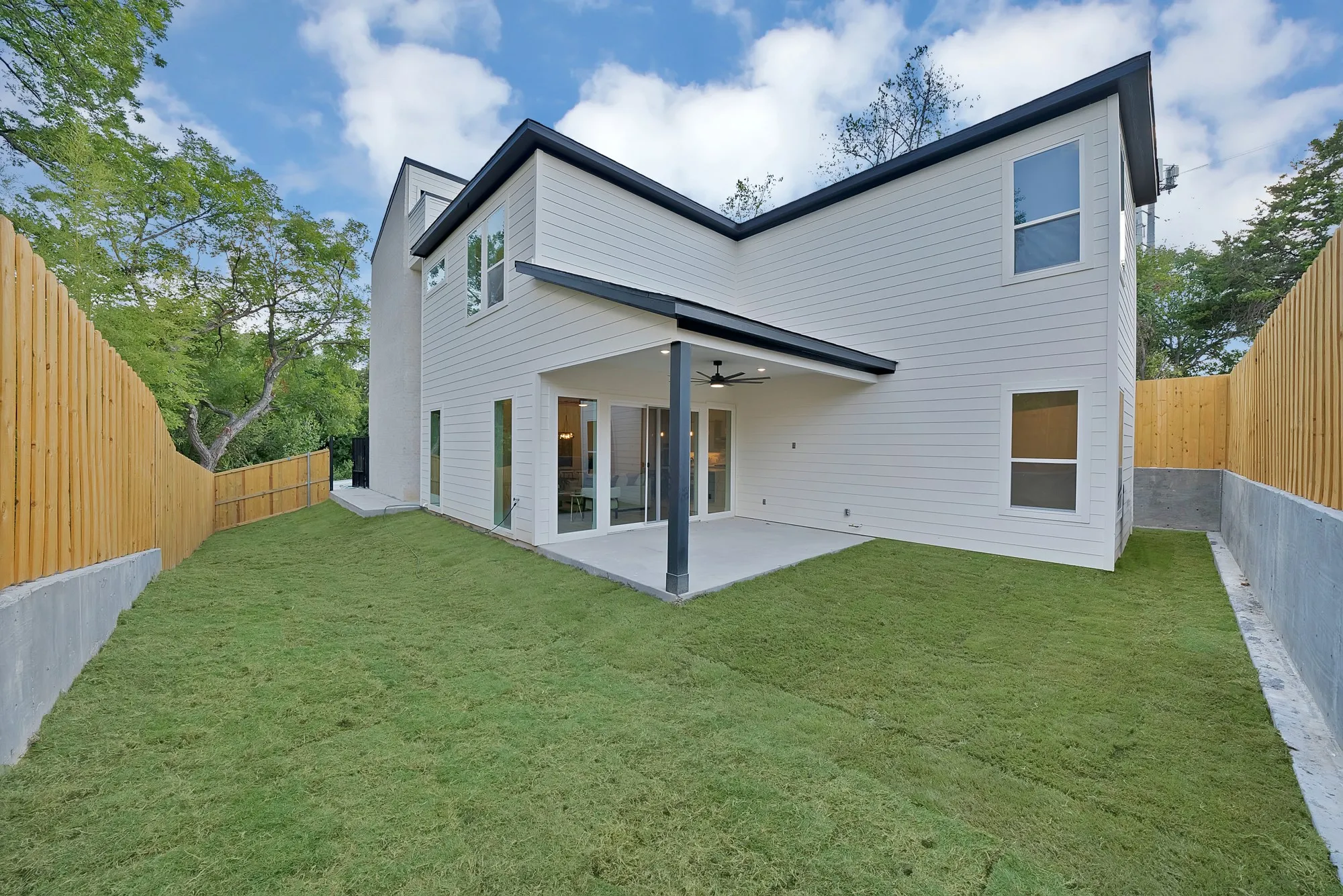 Modern exterior with white siding, black trim, and multiple windows