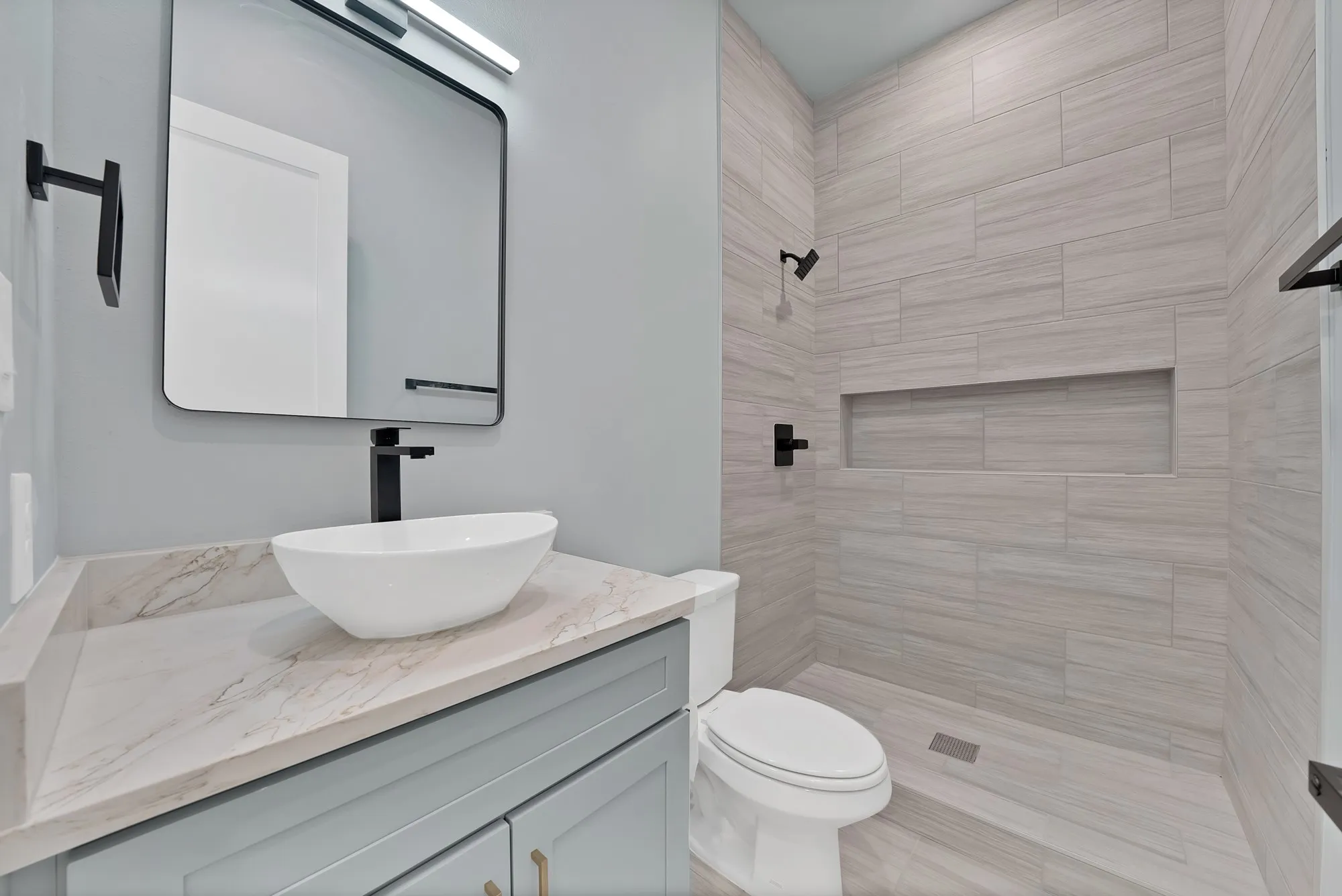 Modern vanity with a vessel sink and stone-finish countertop