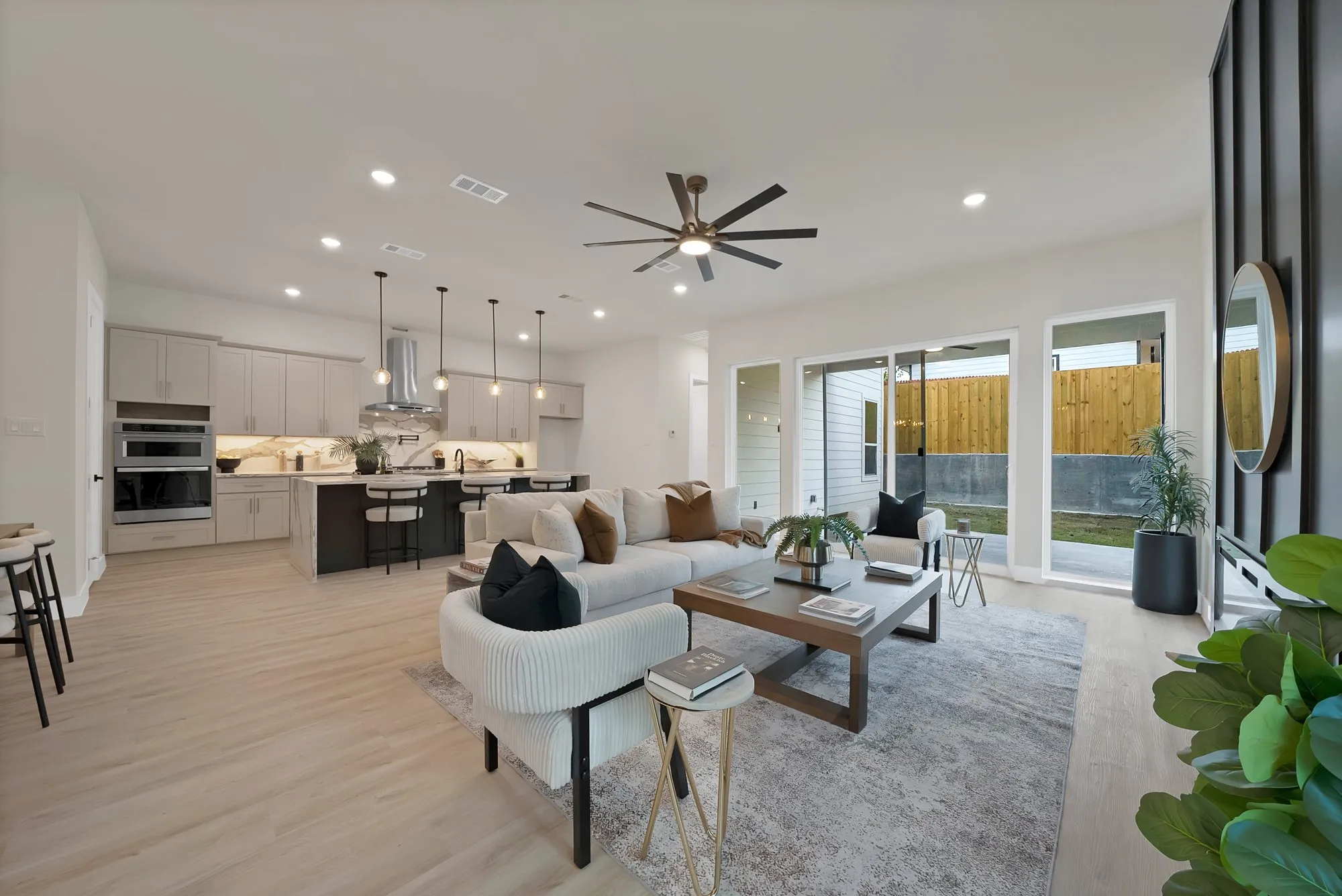 Open-concept living space featuring wood-finish flooring, recessed lighting, and a modern ceiling fan