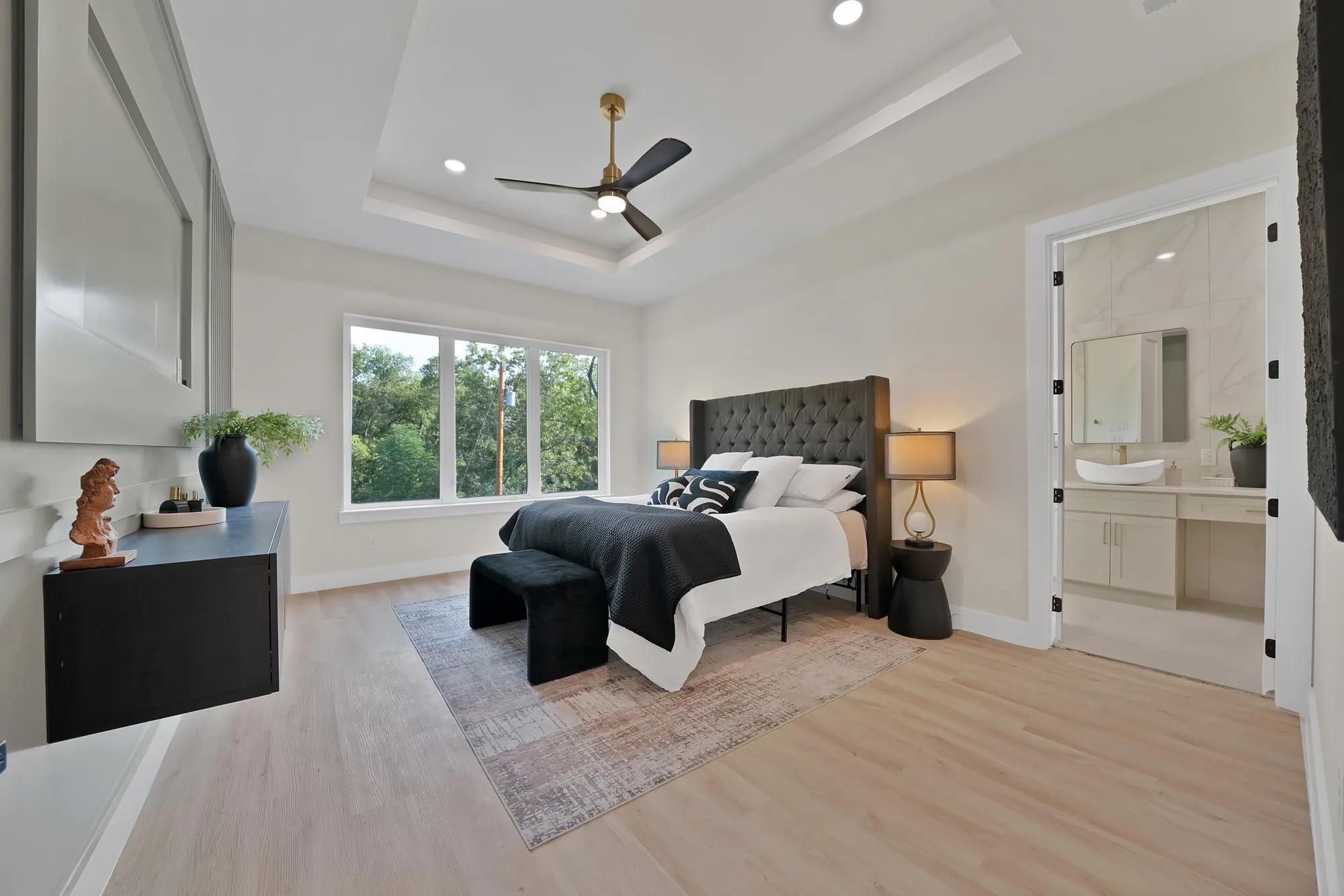Tray ceiling with recessed lighting, ceiling fan, and large windows
