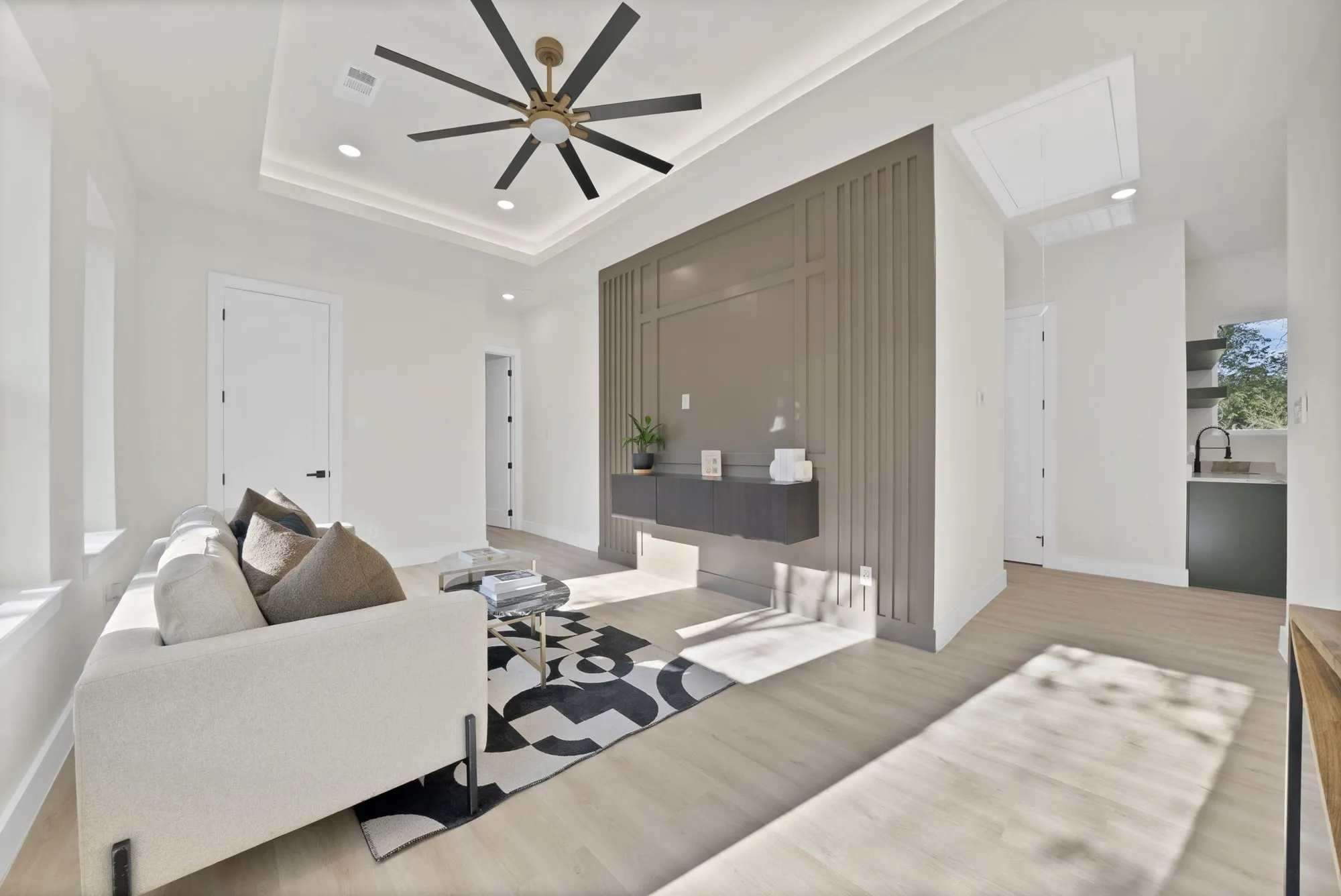 Recessed lighting, wood-finish flooring, tray ceiling, modern ceiling fan, and accent wall paneling