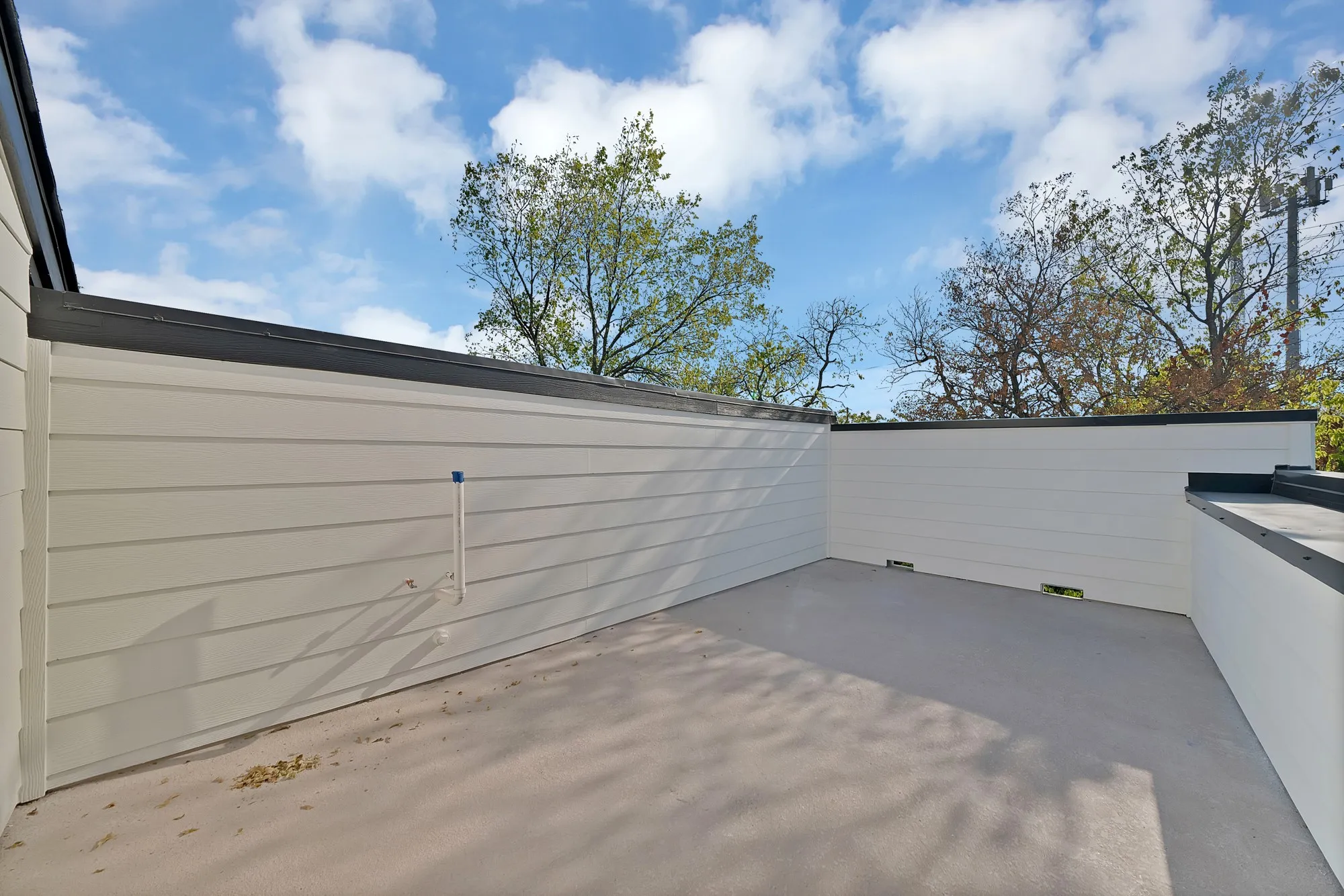 Outdoor patio space featuring smooth concrete flooring and horizontal panel siding