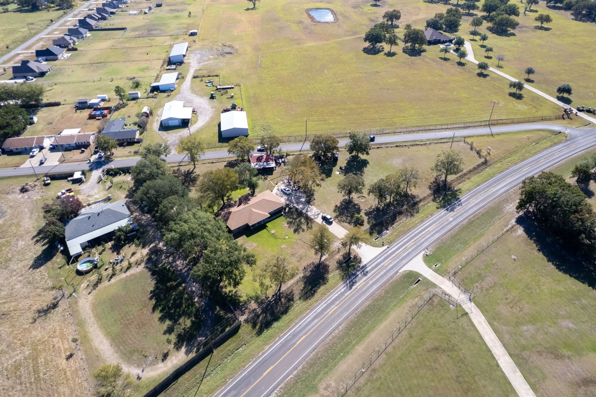 Expansive property featuring a residence, detached buildings, and mature trees