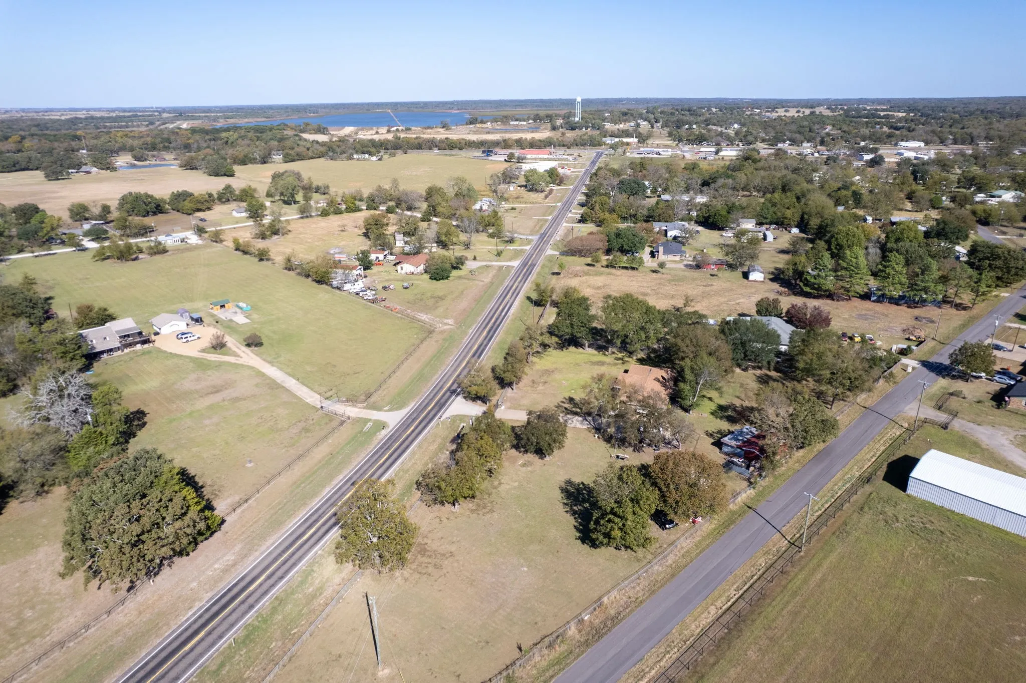 Expansive rural setting with established roads and a distant water feature