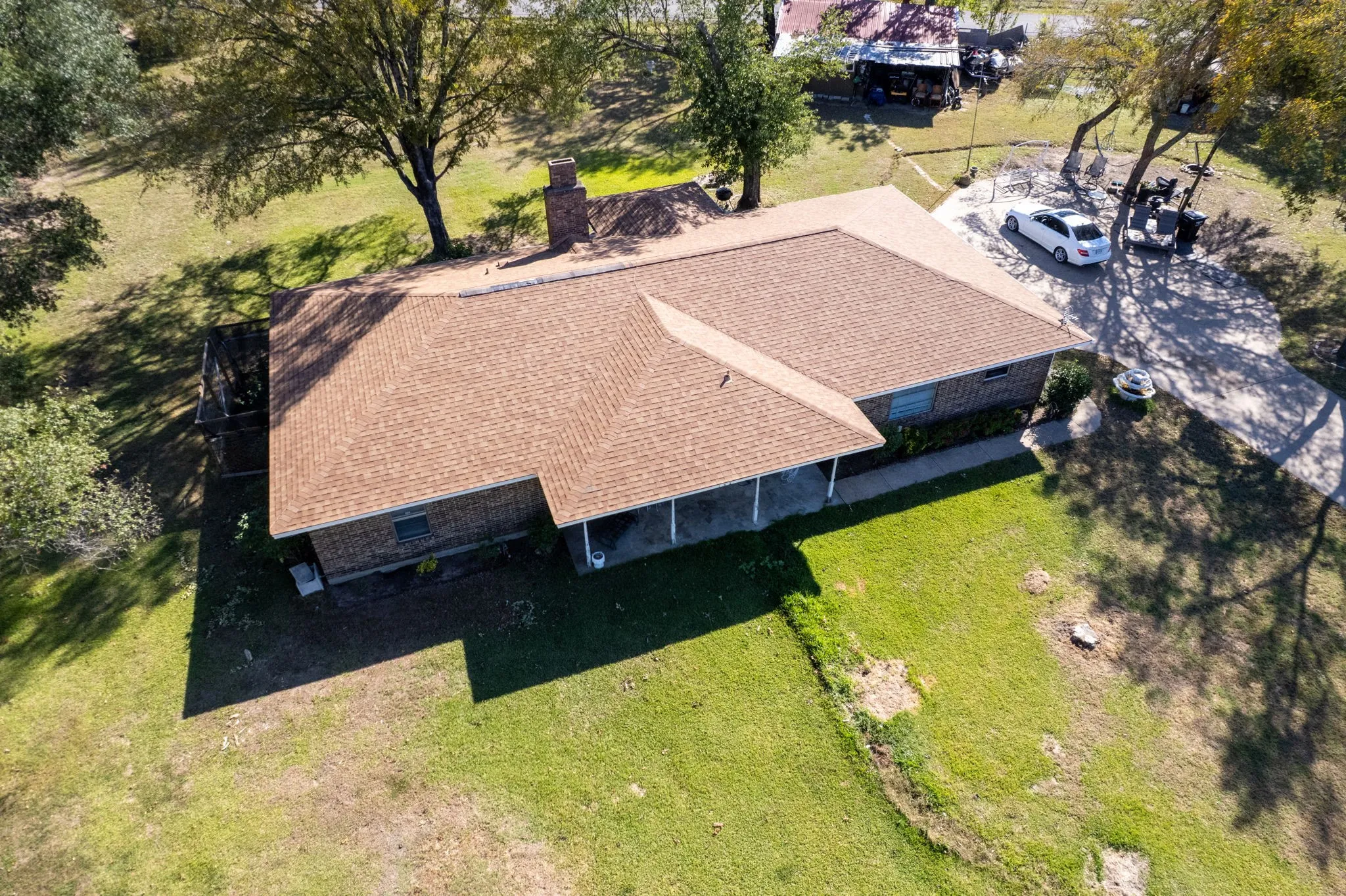 Single-story residence featuring a brown shingle roof, brick exterior, and a covered porch
