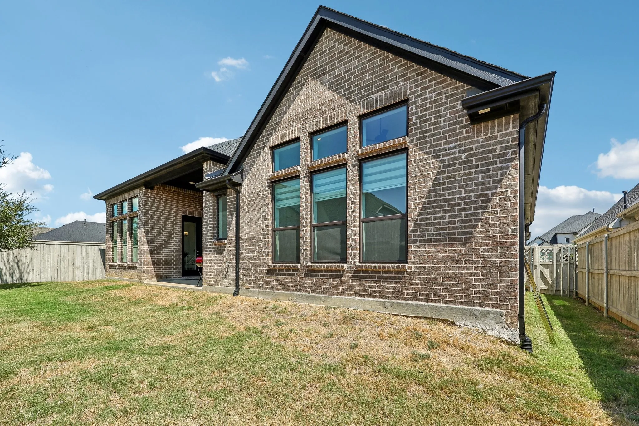 Brick exterior with dark trim and multiple windows