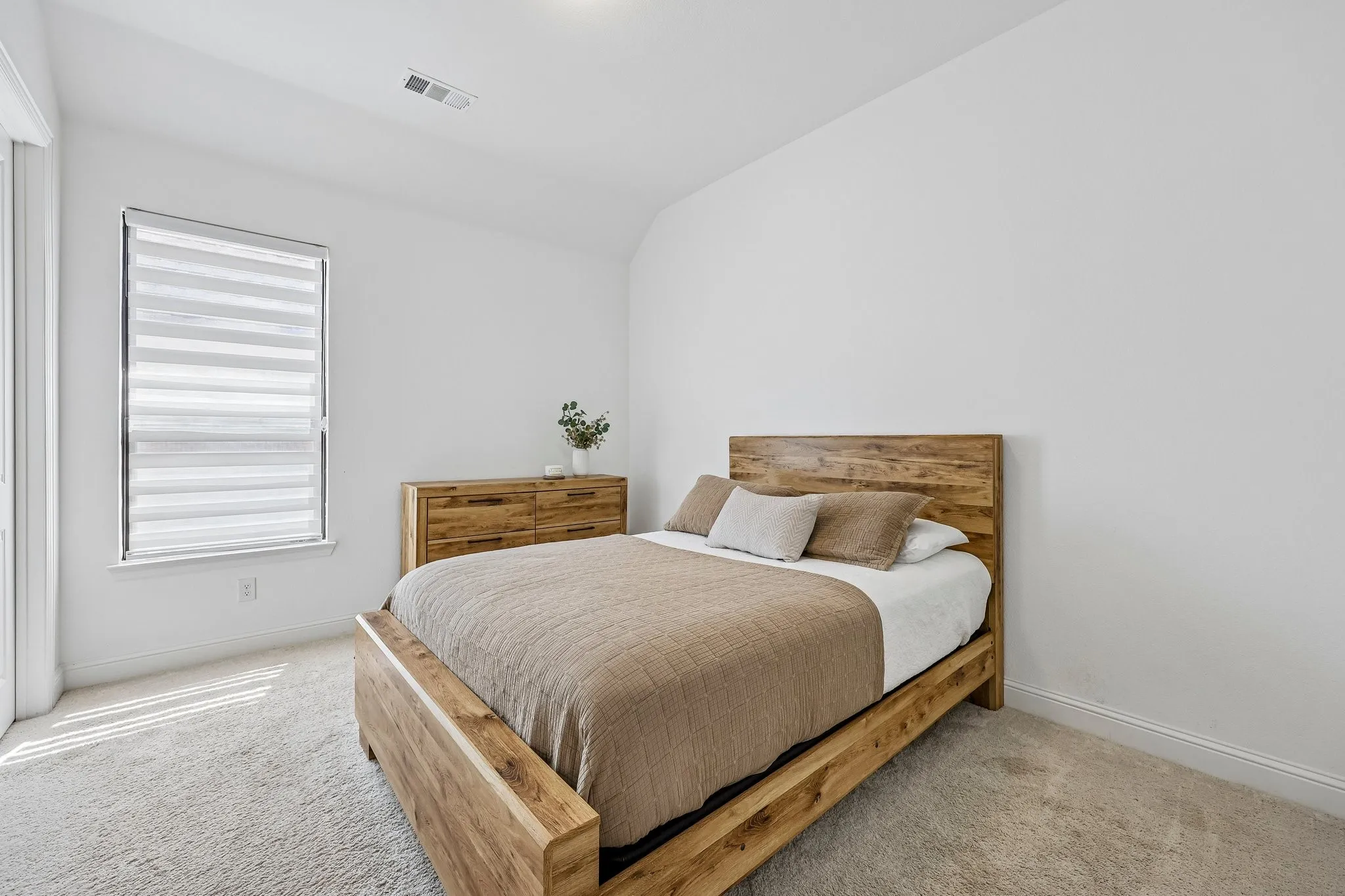 Crisp white walls, neutral carpeting, and a window with horizontal blinds
