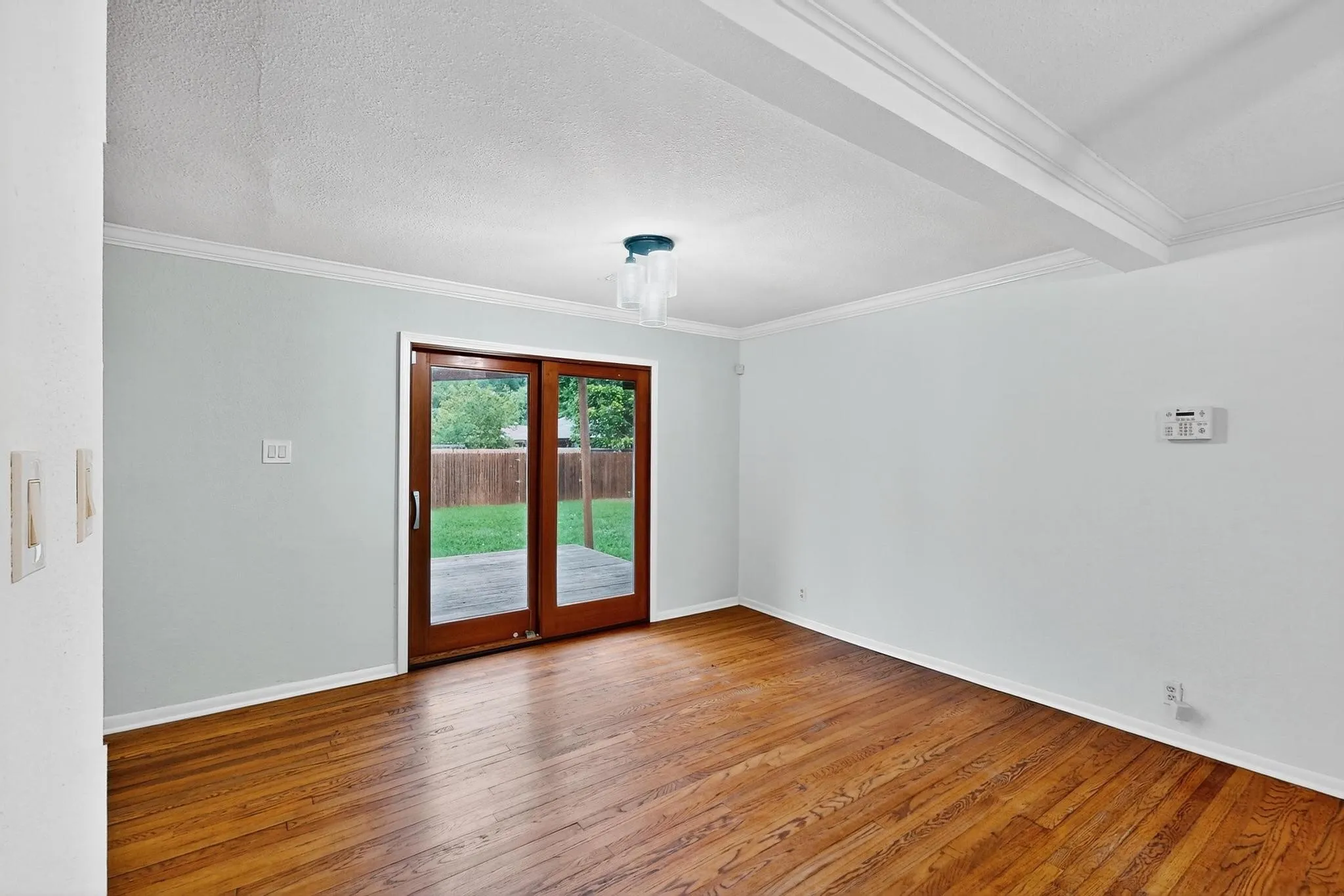 Spare room featuring ornamental molding, hardwood / wood-style flooring, and a textured ceiling