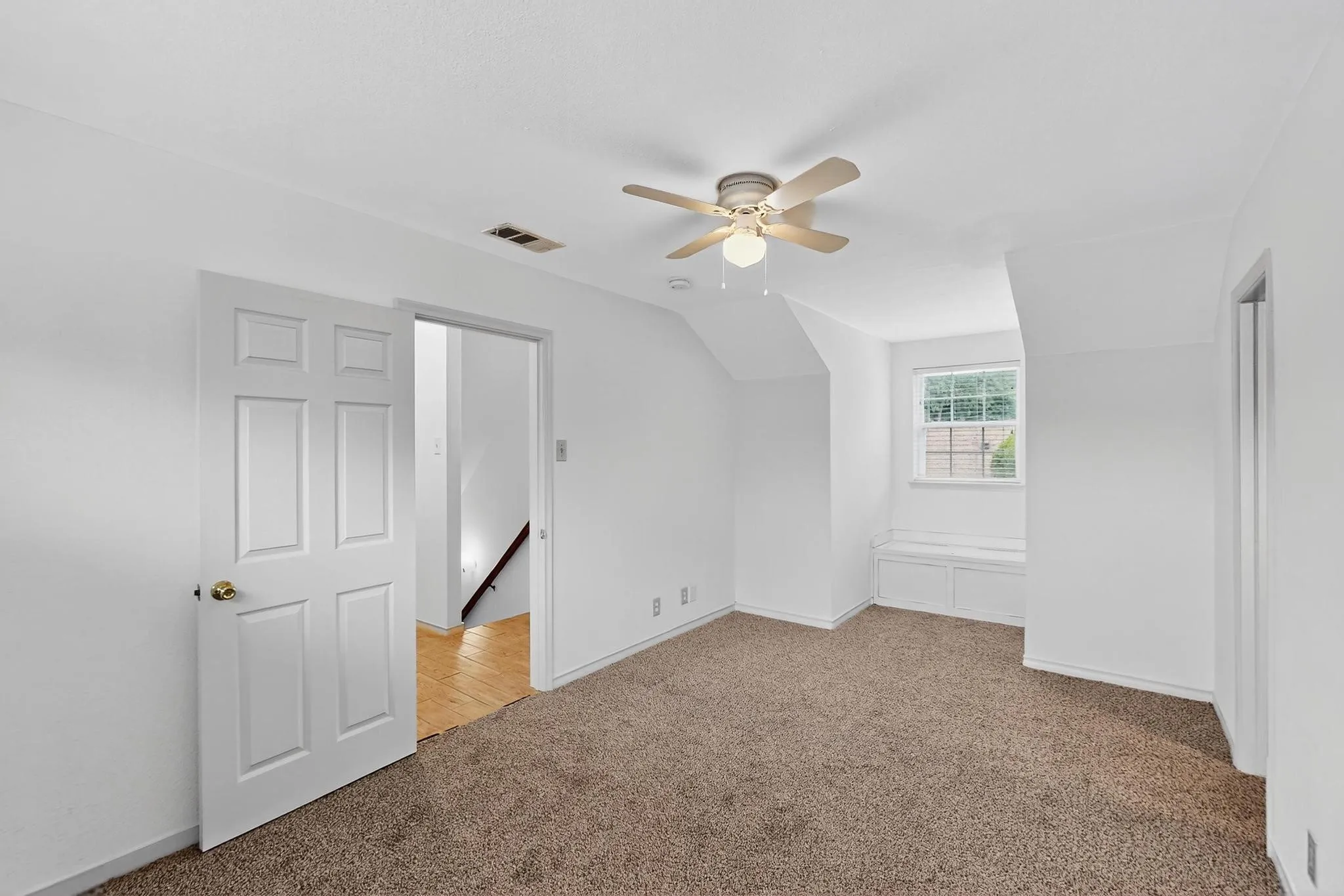 Additional living space featuring light colored carpet, a ceiling fan, and lofted ceiling