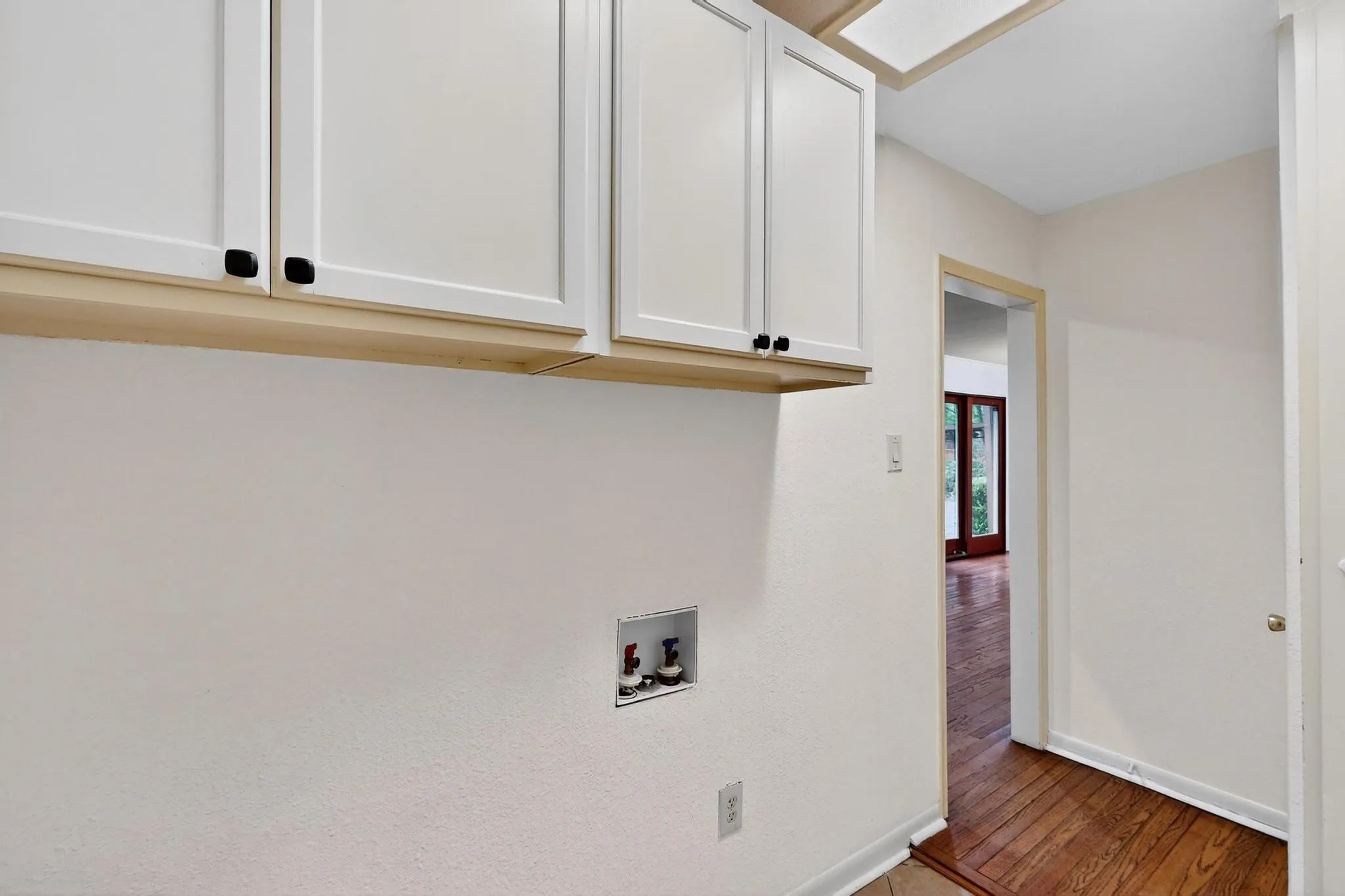 Washroom featuring cabinet space, washer hookup, and wood finished floors