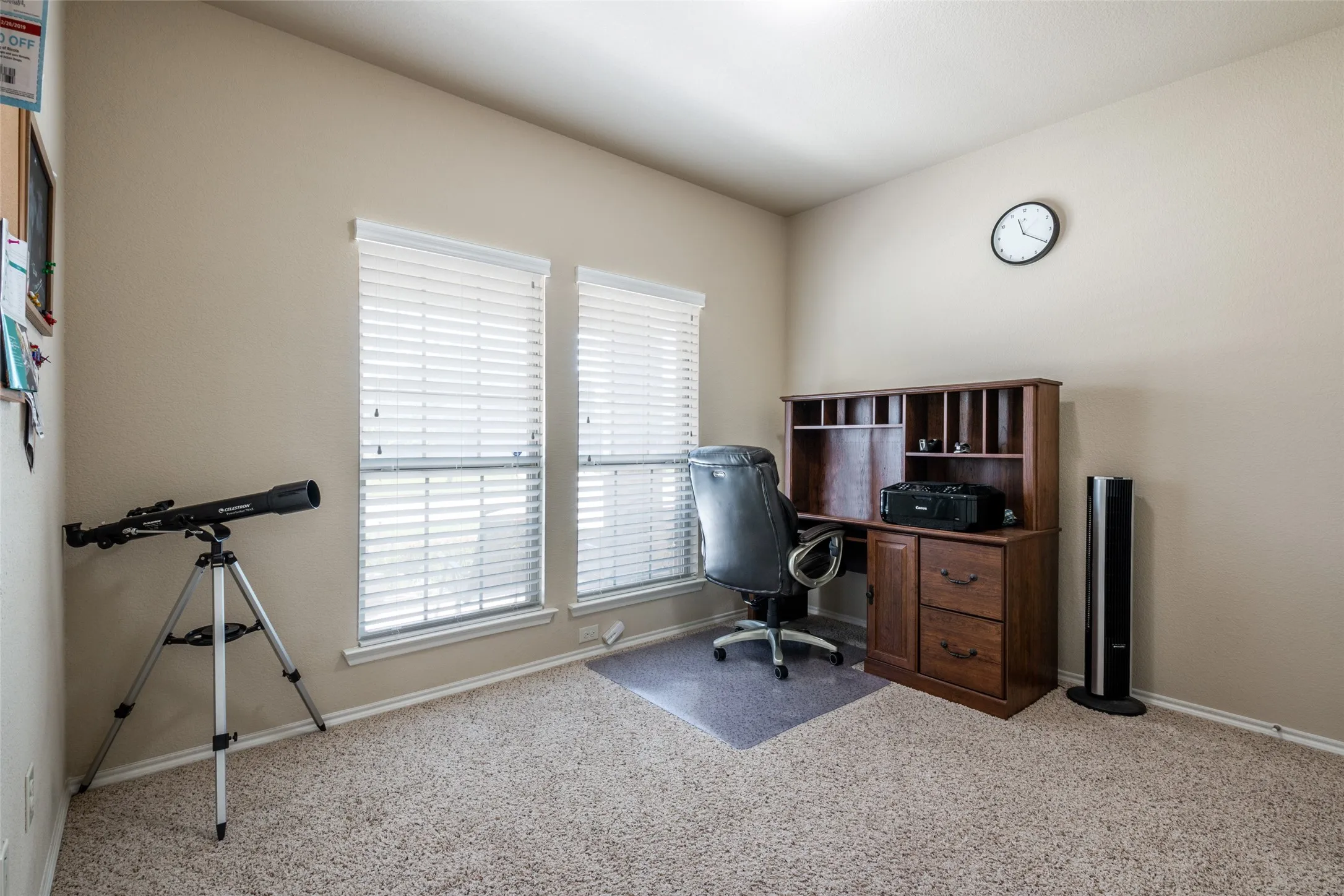 Carpeted home office with healthy amount of natural light